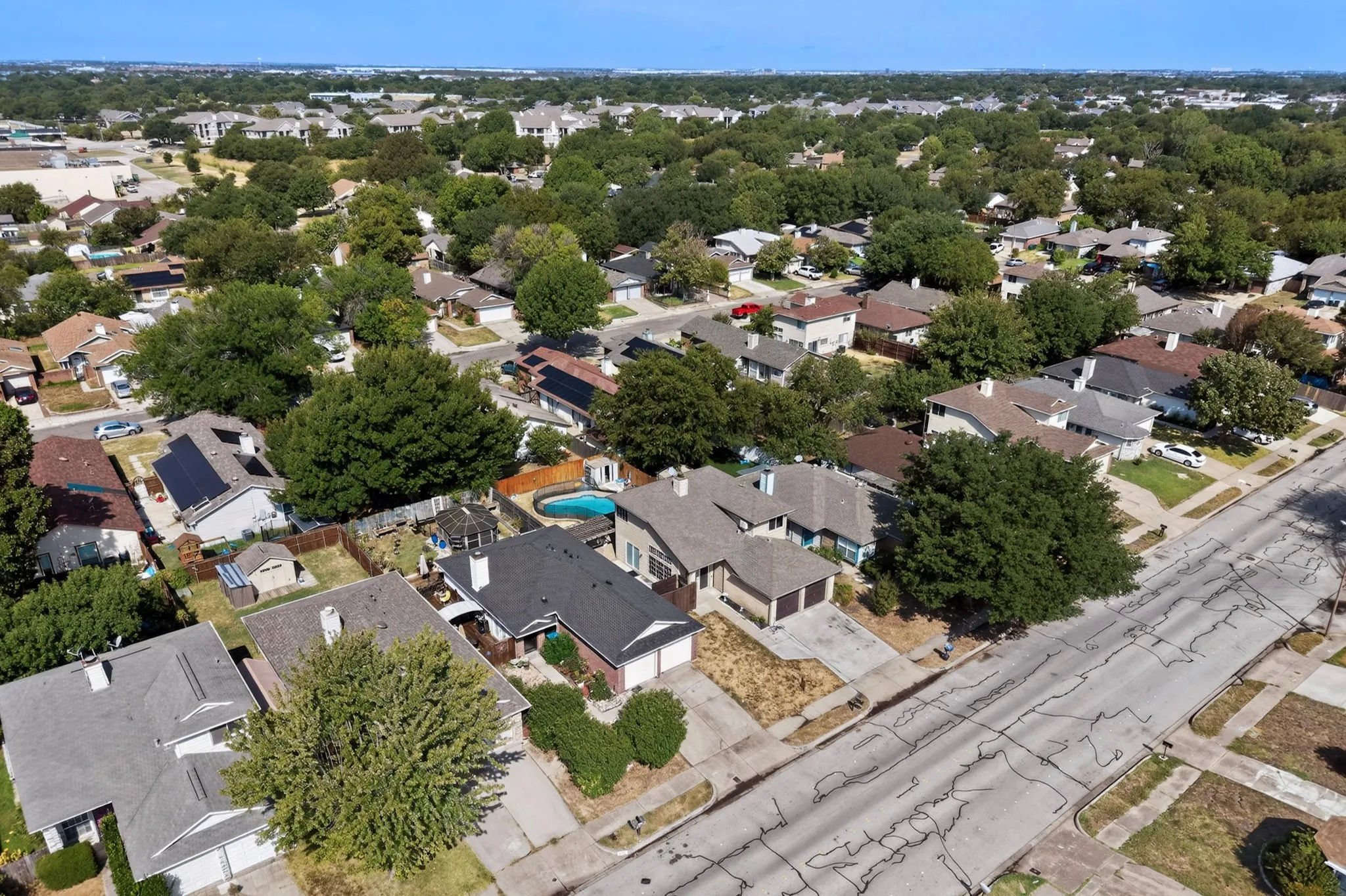 Residential neighborhood with mature trees and a clear sky
