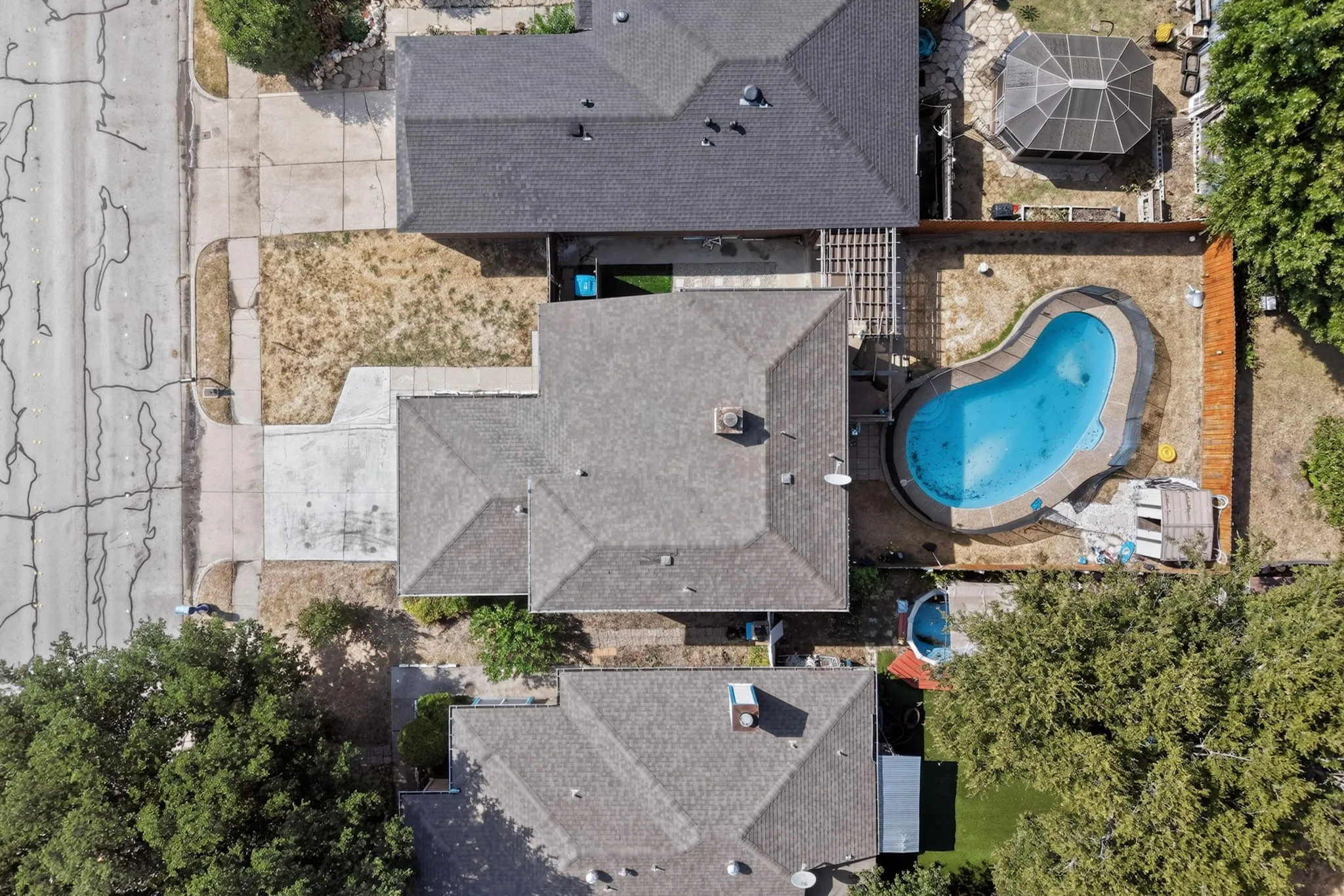 Rear yard featuring an in-ground swimming pool, a detached covered patio structure, and a perimeter fence