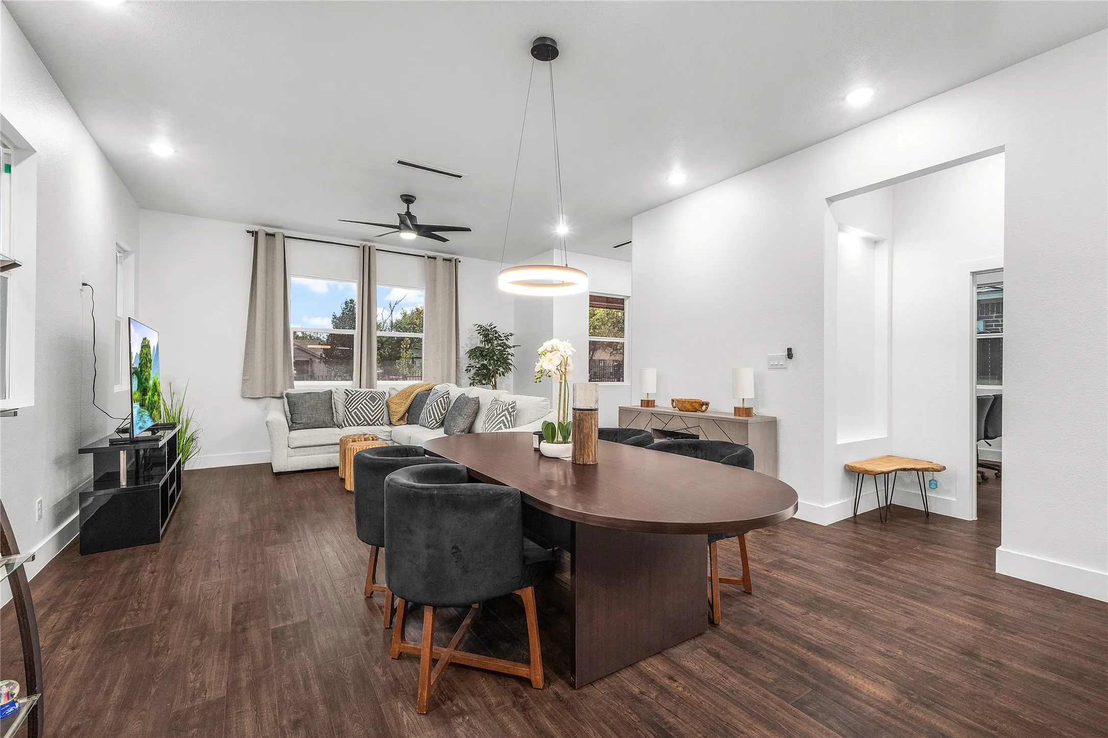 Open-concept living area featuring wood-finish flooring, recessed lighting, and a modern ceiling fan