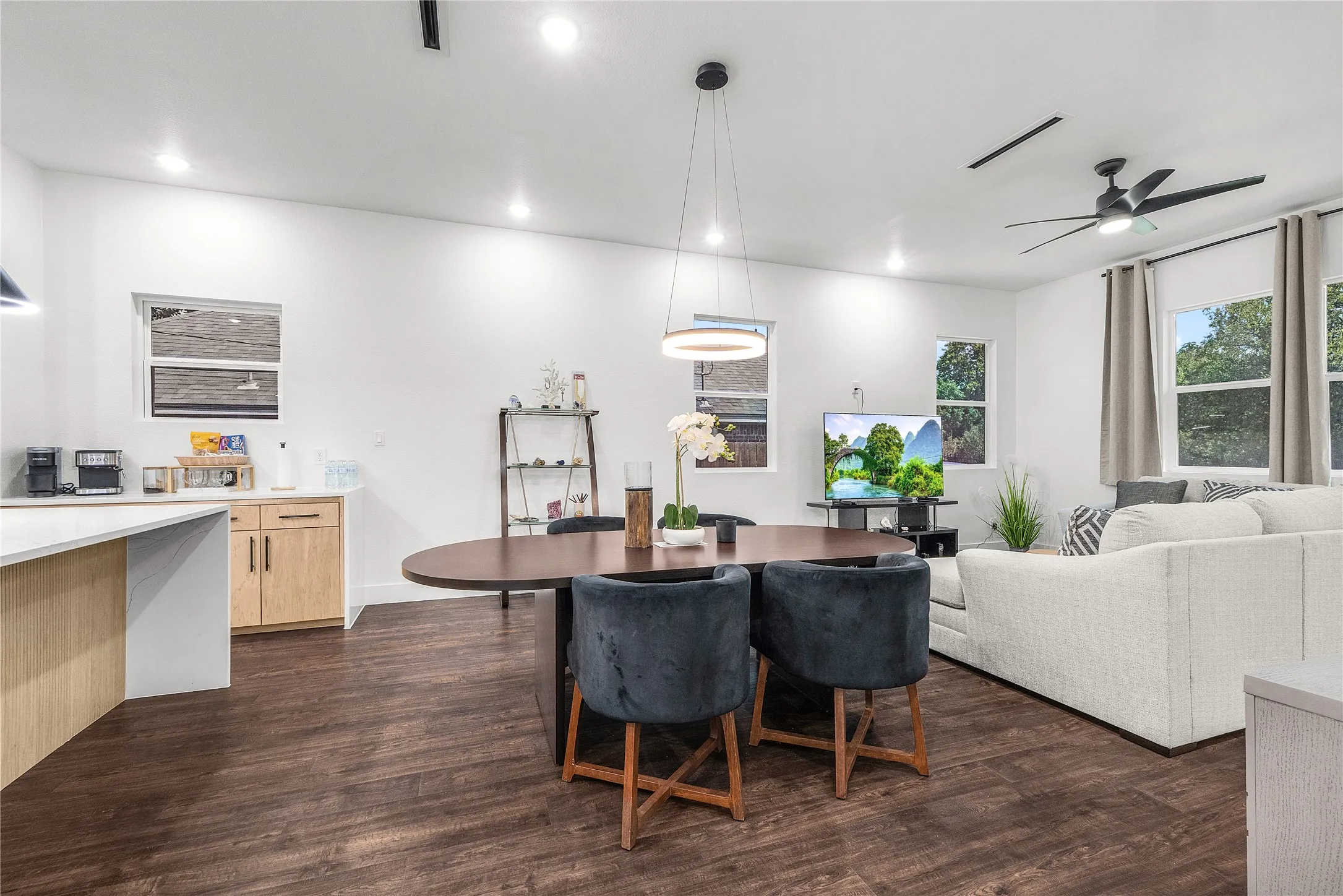Wood-finish flooring, recessed lighting, and multiple windows with curtain rods
