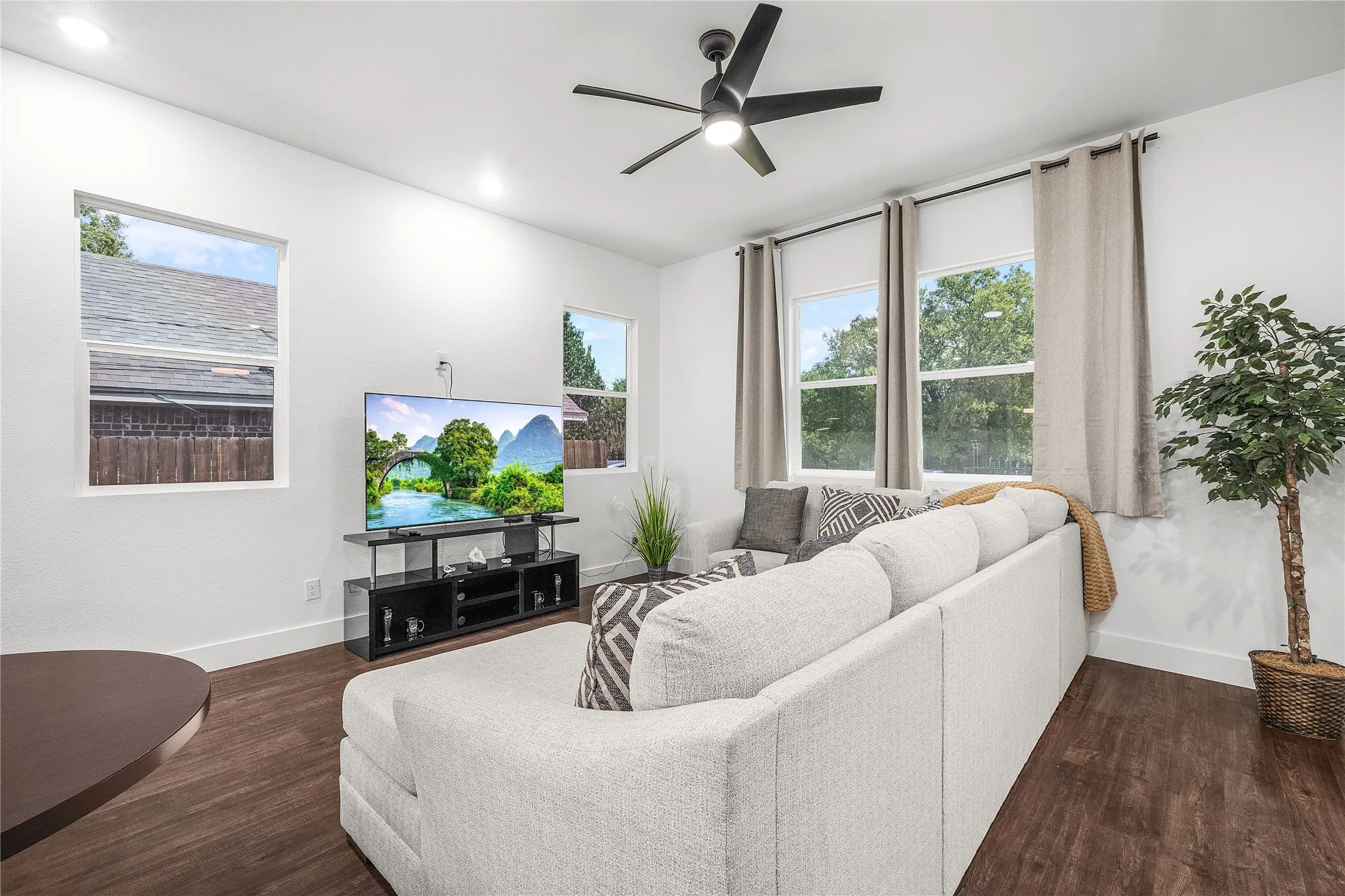 Spacious living area featuring wood-finish flooring, recessed lighting, and a contemporary ceiling fan