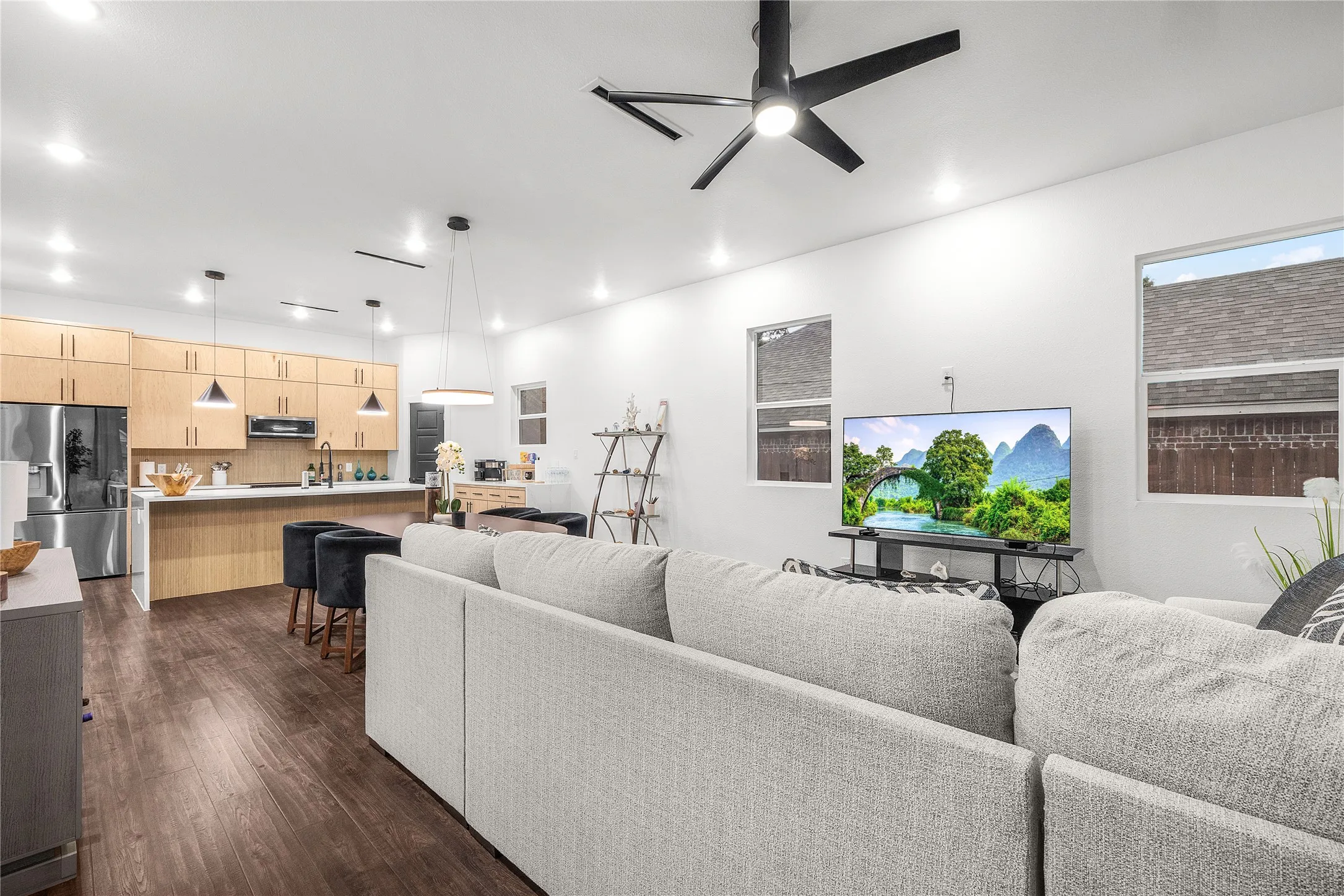Open-concept living space with dark wood-finish flooring, recessed lighting, and a contemporary ceiling fan