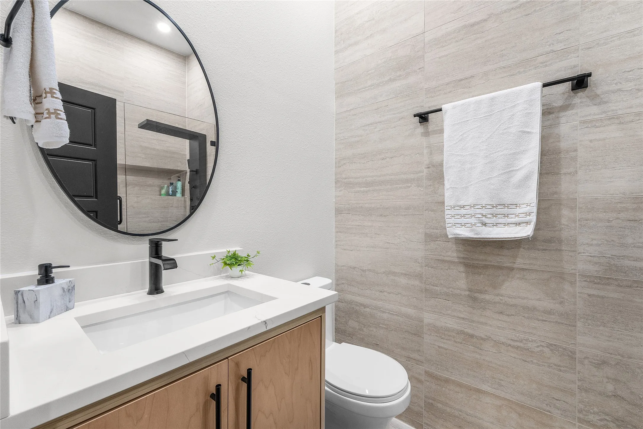 Vanity with a rectangular undermount sink, quartz countertop, and wood-finish cabinetry