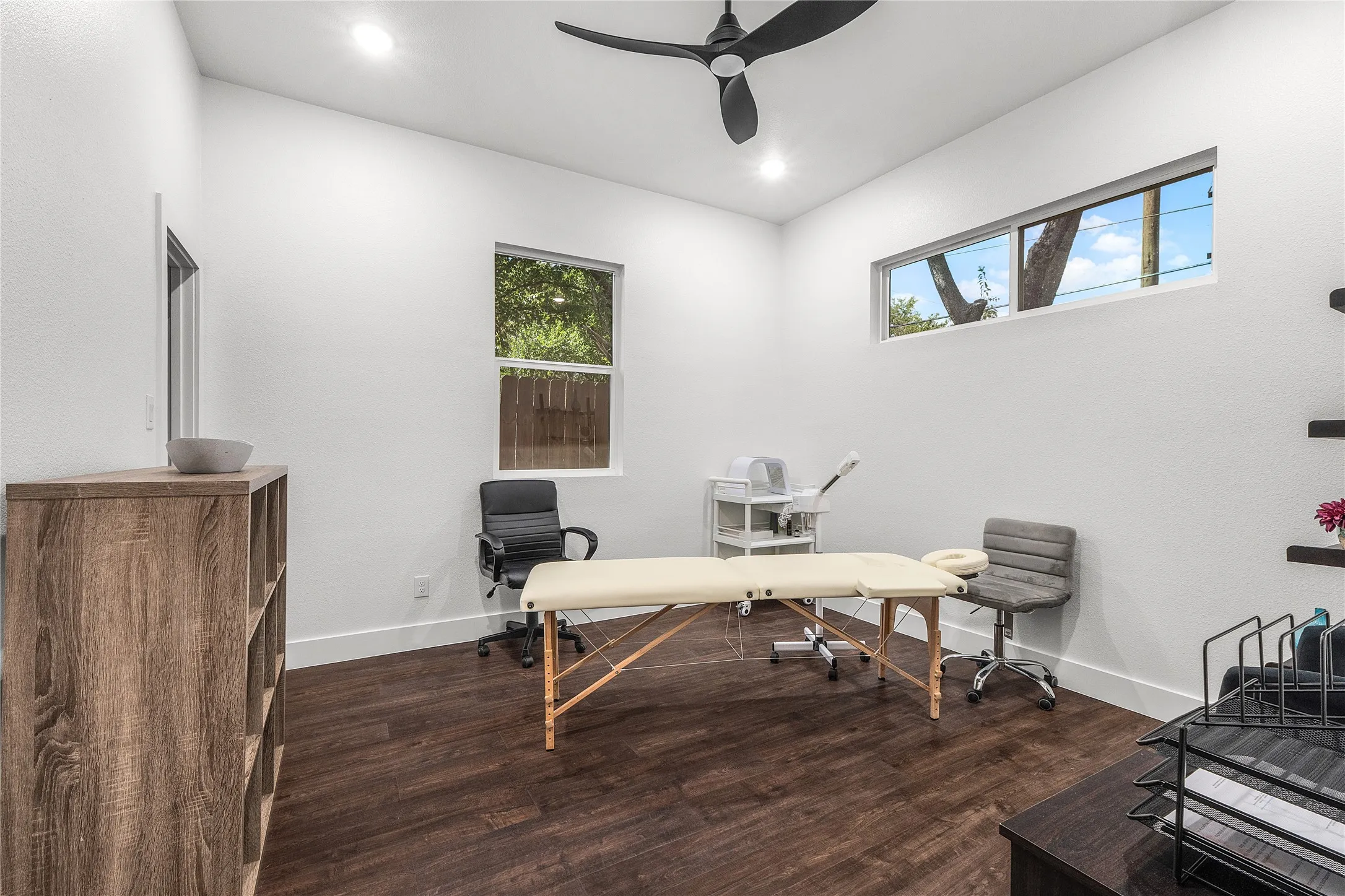 Wood-finish flooring with white walls and recessed lighting