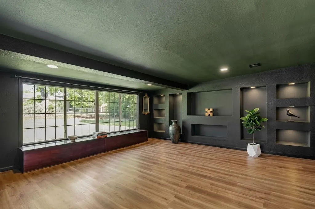 Wood-finish flooring, recessed lighting, built-in display niches, and a large grid-pane window with a built-in window seat