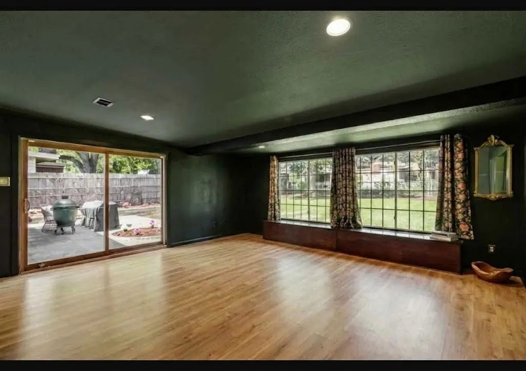 Wood-finish flooring, recessed ceiling lighting, large sliding glass door, and two multi-pane windows with integrated window box storage