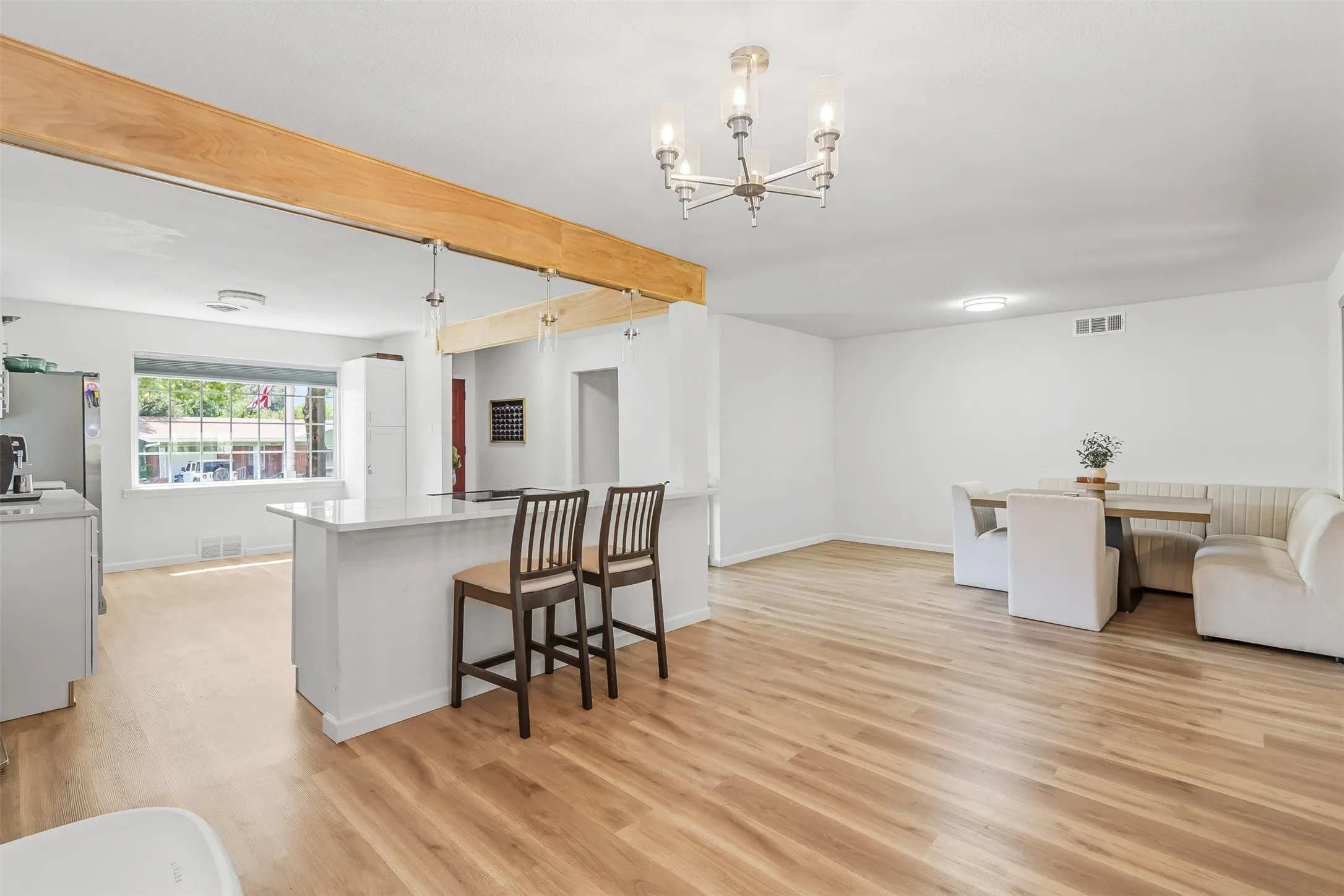 Expansive wood-finish flooring, white walls, and a recessed ceiling light