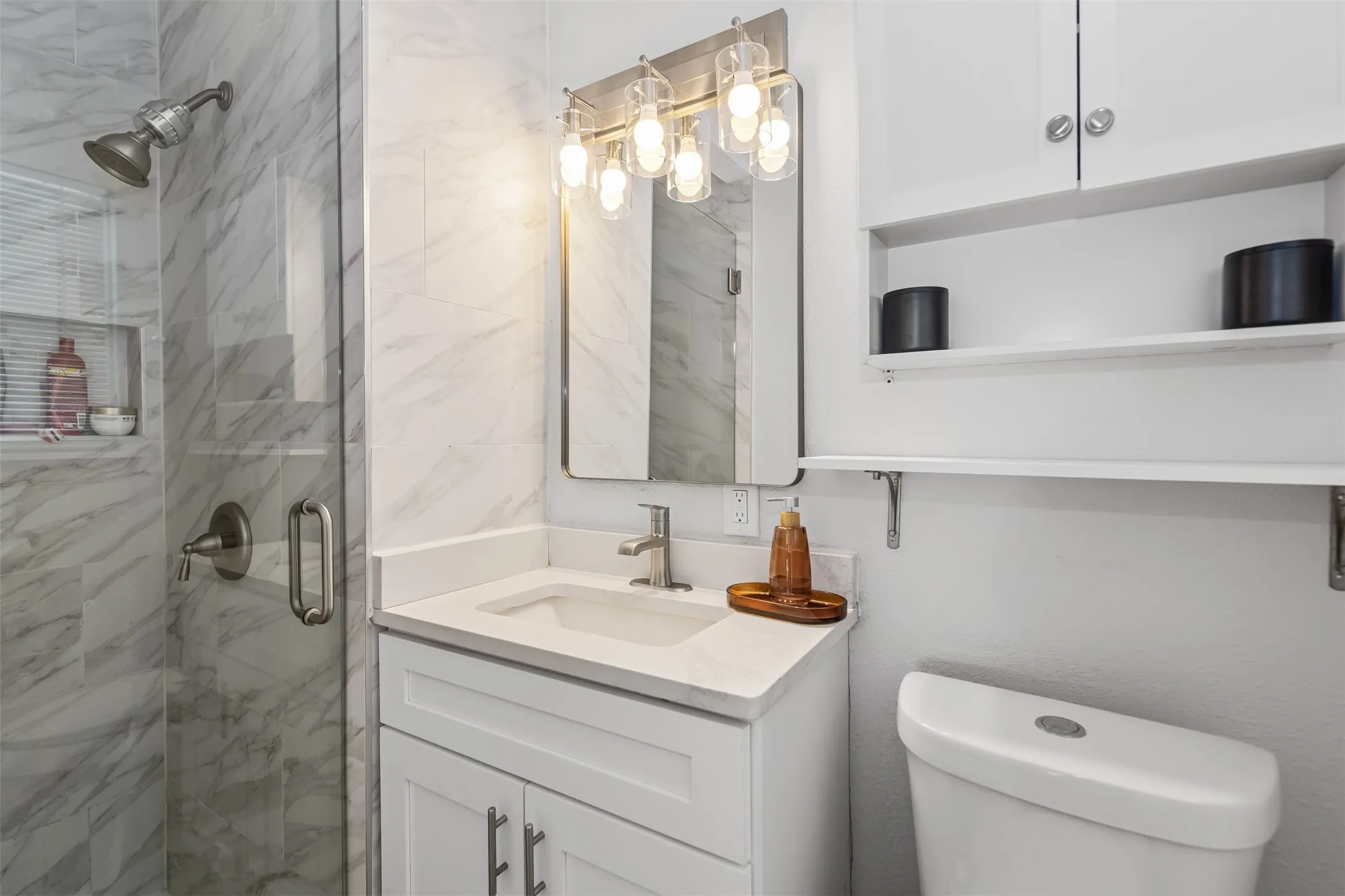 Glass-enclosed shower with tiled walls and a built-in niche