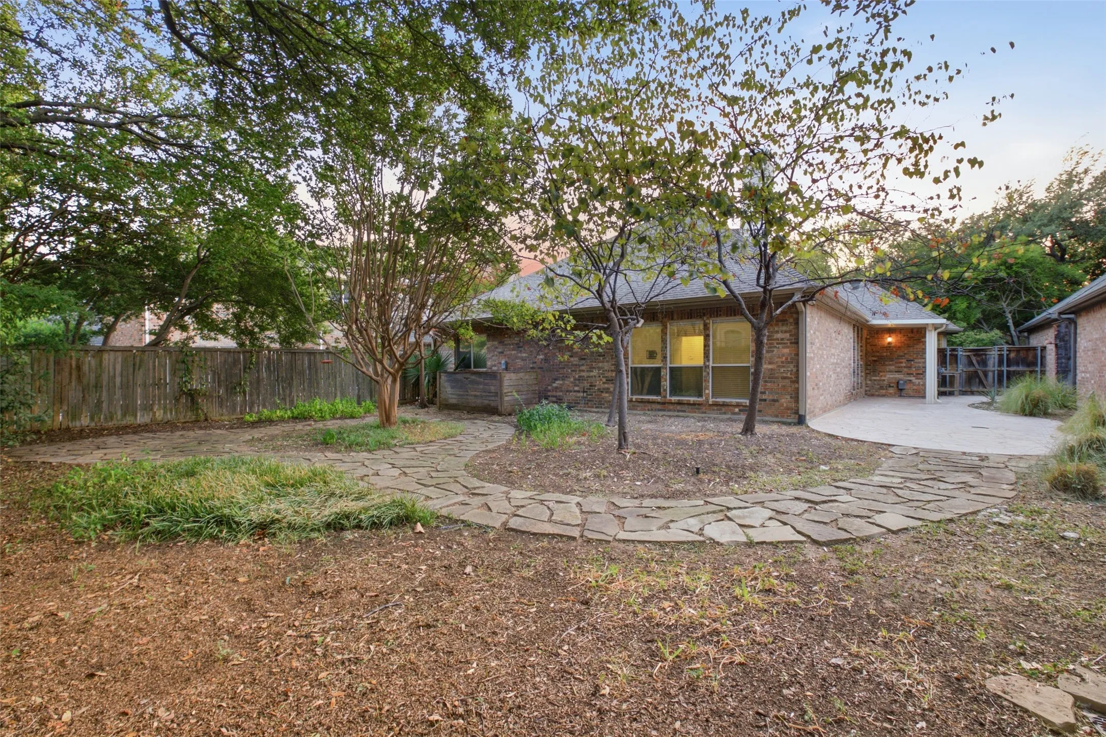 Golden hour on classic brick and a sweeping stamped-concrete patio built for entertaining