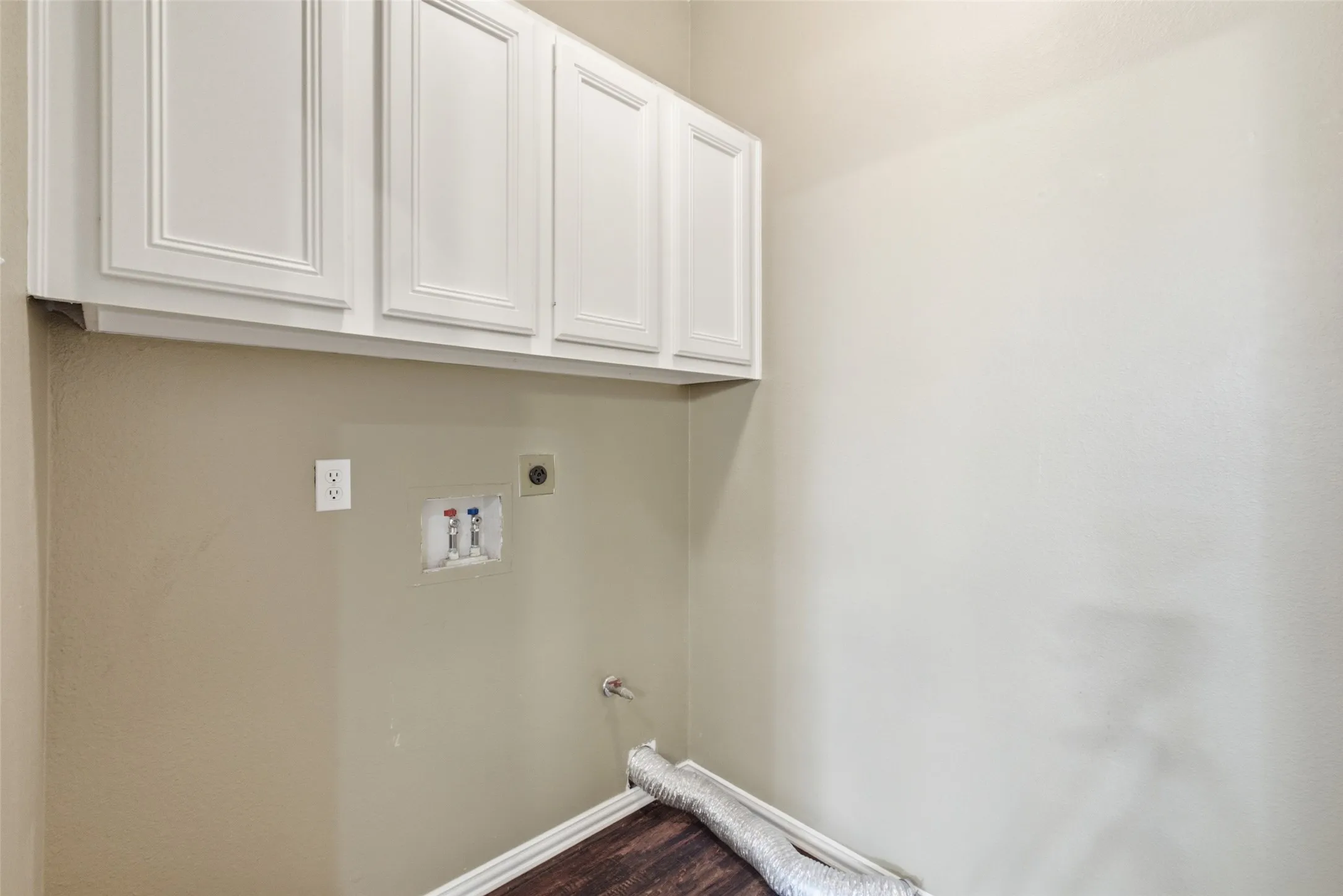 Dedicated laundry room with overhead cabinetry and full-size washer/dryer connections