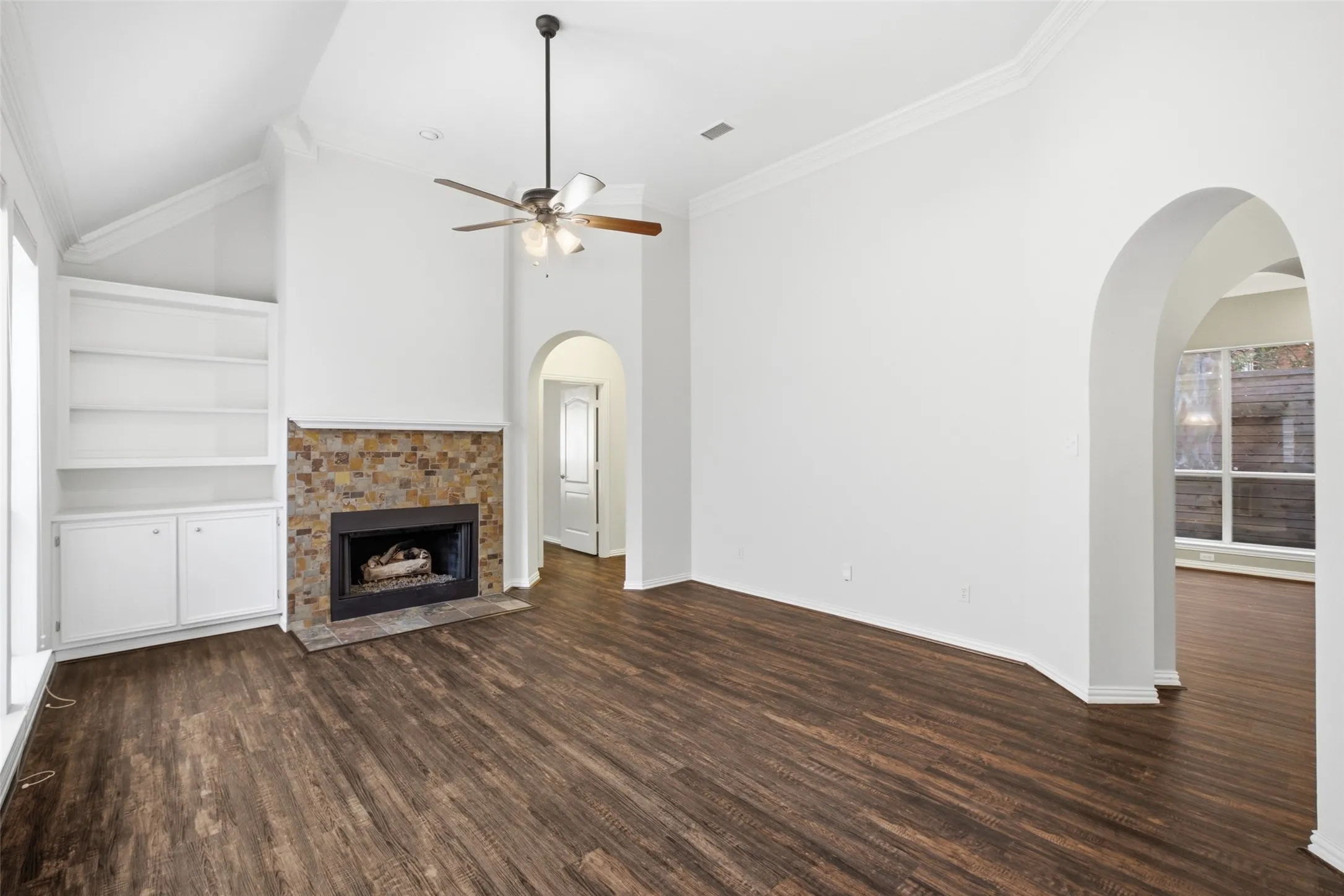 Living space under a soaring vault — stacked-stone fireplace and built-ins already done for you