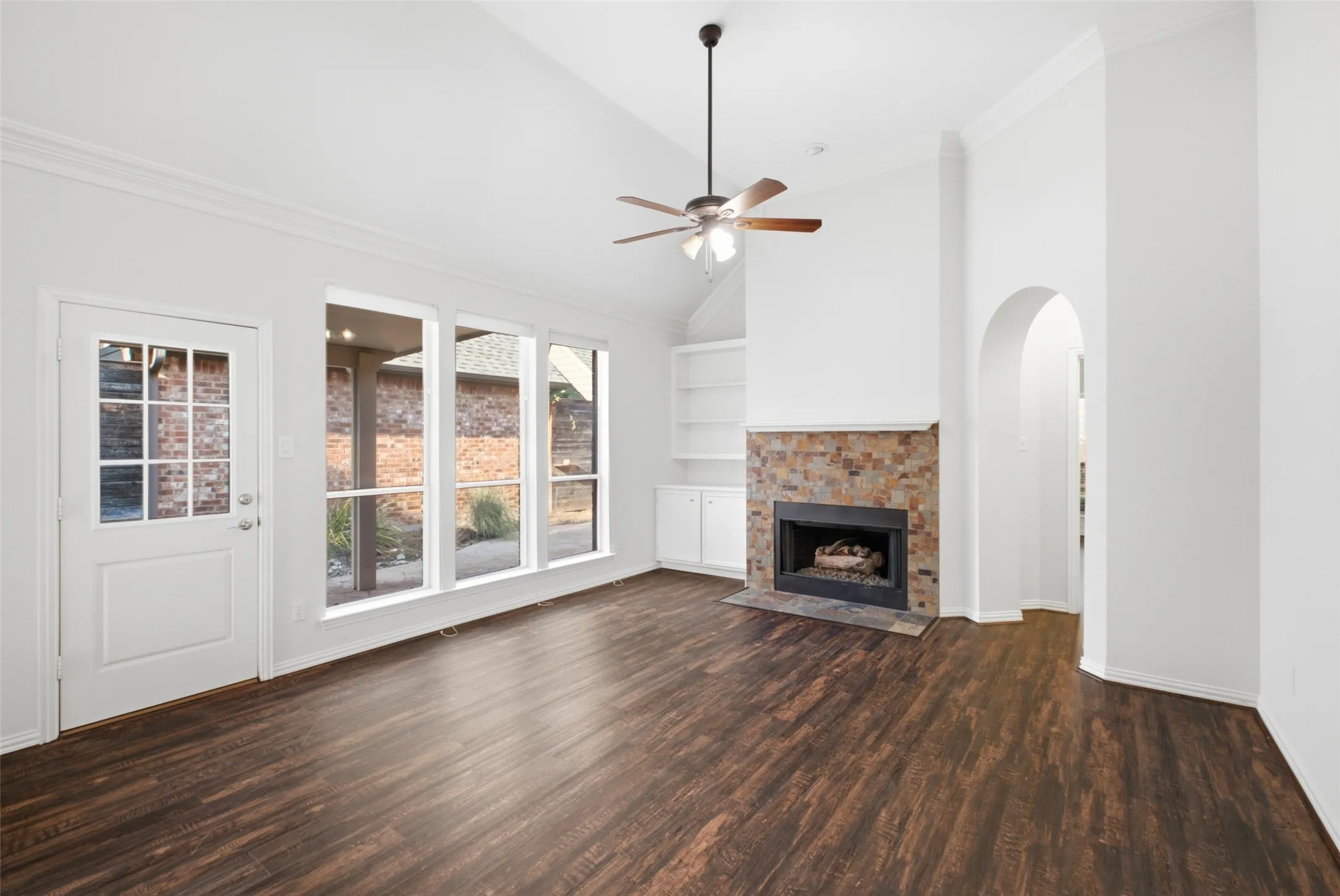 Wall of windows to the patio and a fireplace that anchors the room — light all day, warmth all winter
