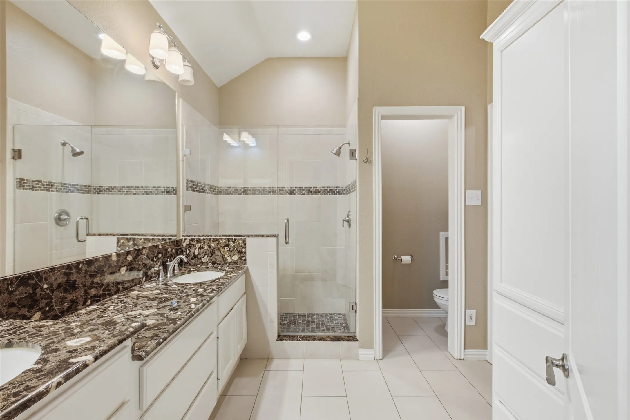 Primary bath: dual granite vanity, oversized walk-in shower and a private water closet