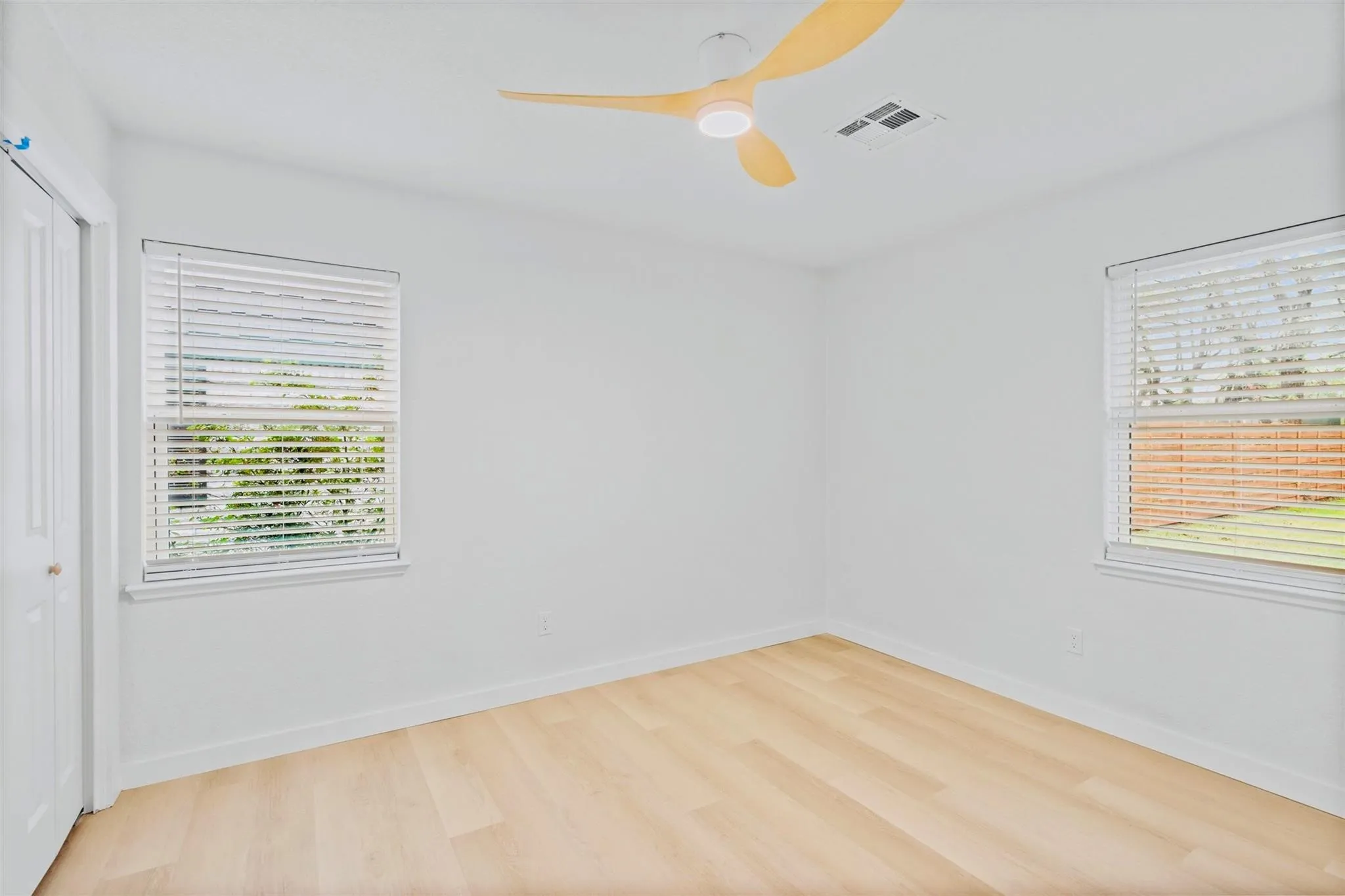 Light wood-finish flooring with white walls and trim