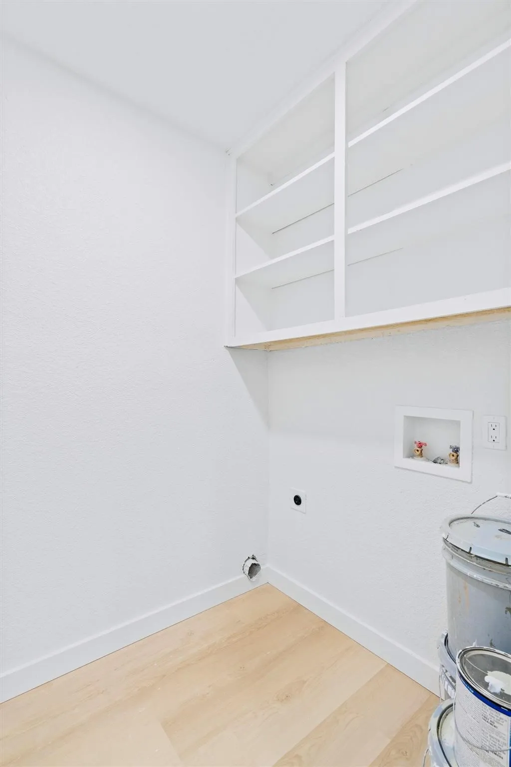 Built-in shelving, wood-finish flooring, and white walls