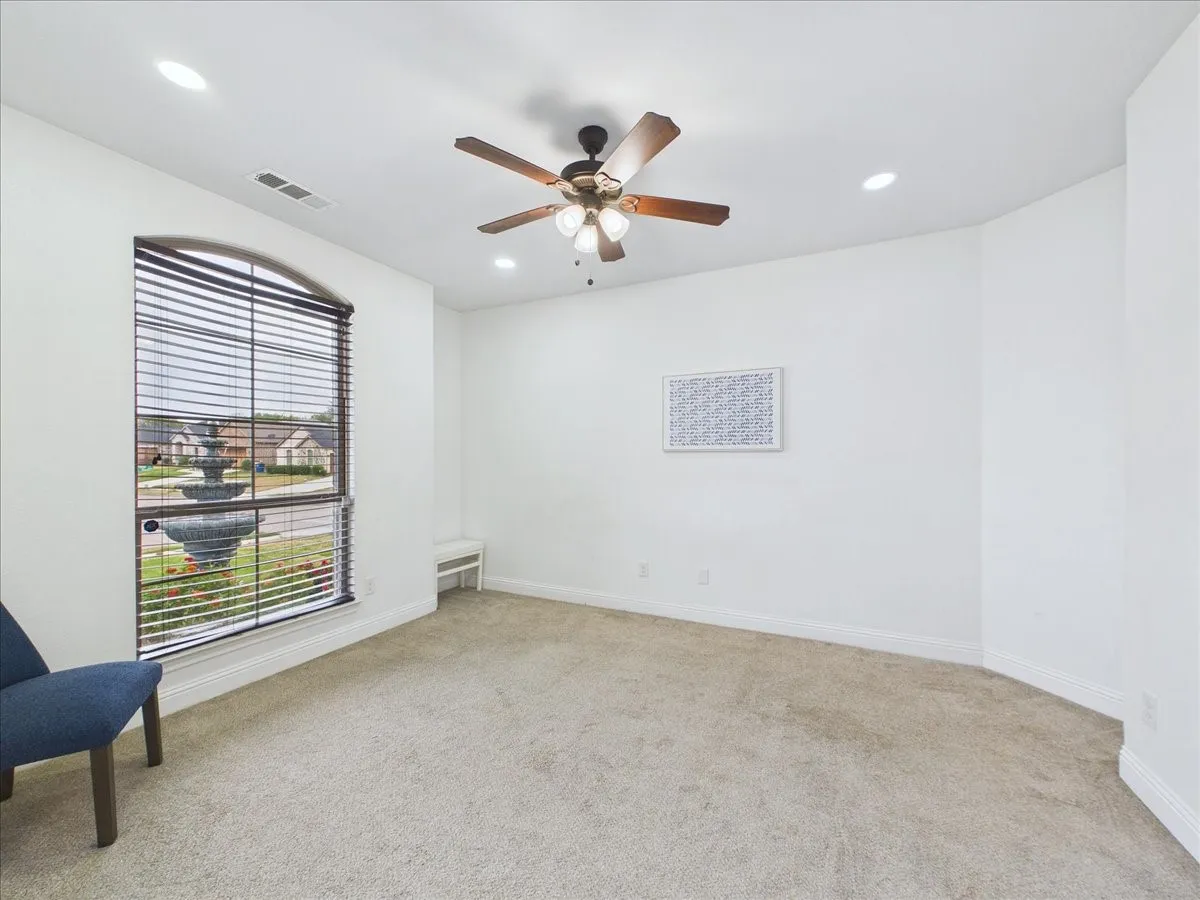 Arched window with blinds, ceiling fan with light fixture, recessed lighting, and built-in bench