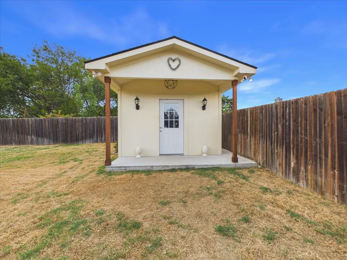 Detached structure with a covered porch, solid wood support beams, and a concrete foundation