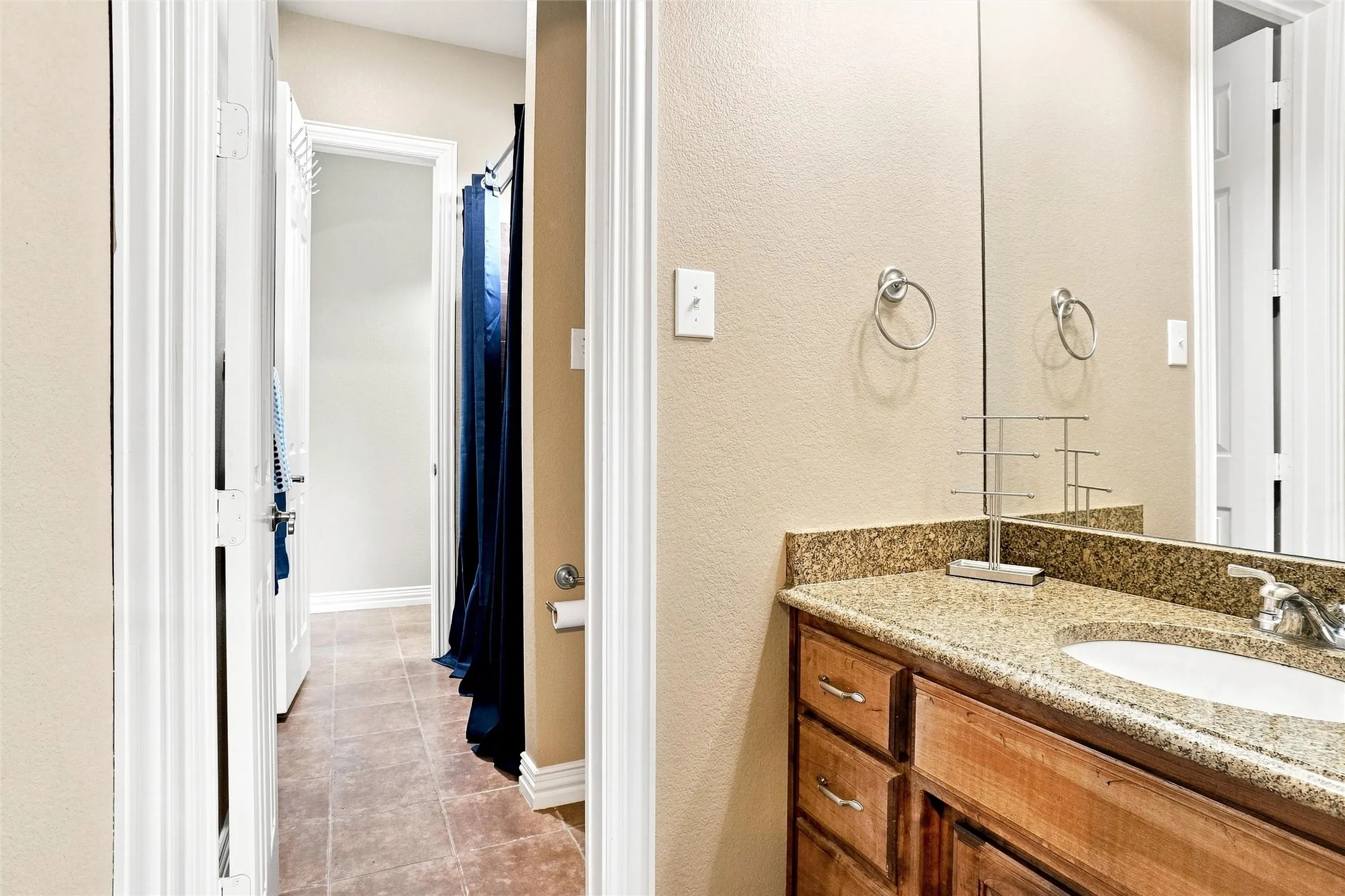 Bathroom vanity featuring a light-toned countertop, integrated sink, and wood-finish cabinetry