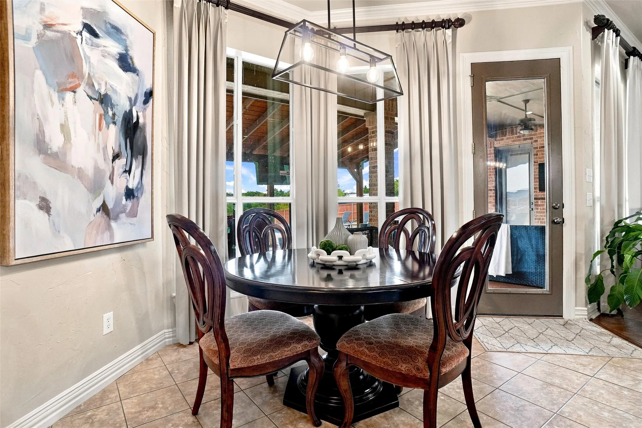 Room featuring large windows, a glass-paneled exterior door, and tile flooring