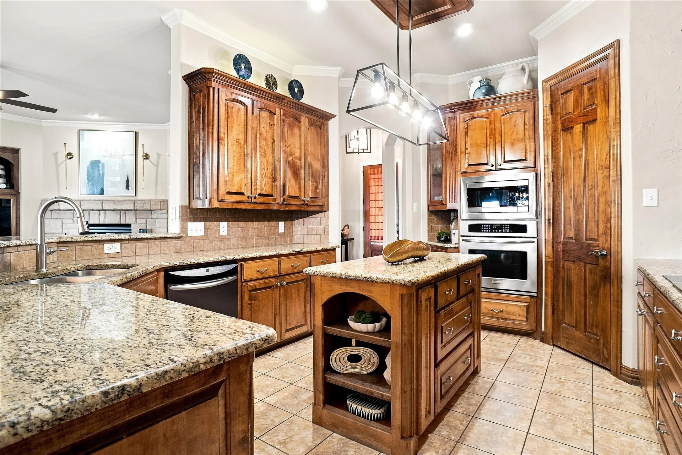 Kitchen featuring granite countertops, wood cabinetry, stainless steel appliances, a center island with storage, and tile flooring