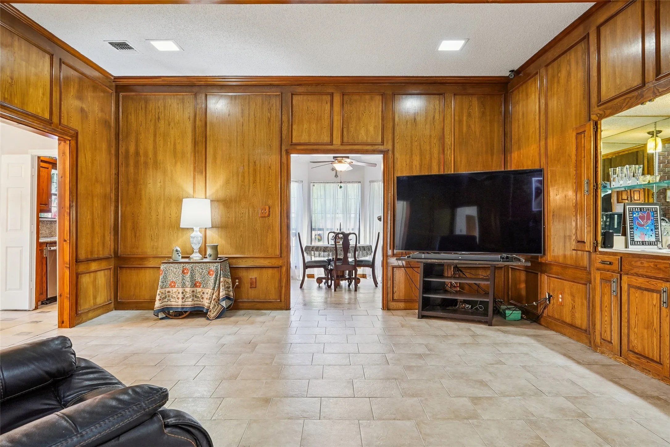 Wood paneling throughout, tile flooring, built-in cabinetry, and integrated lighting