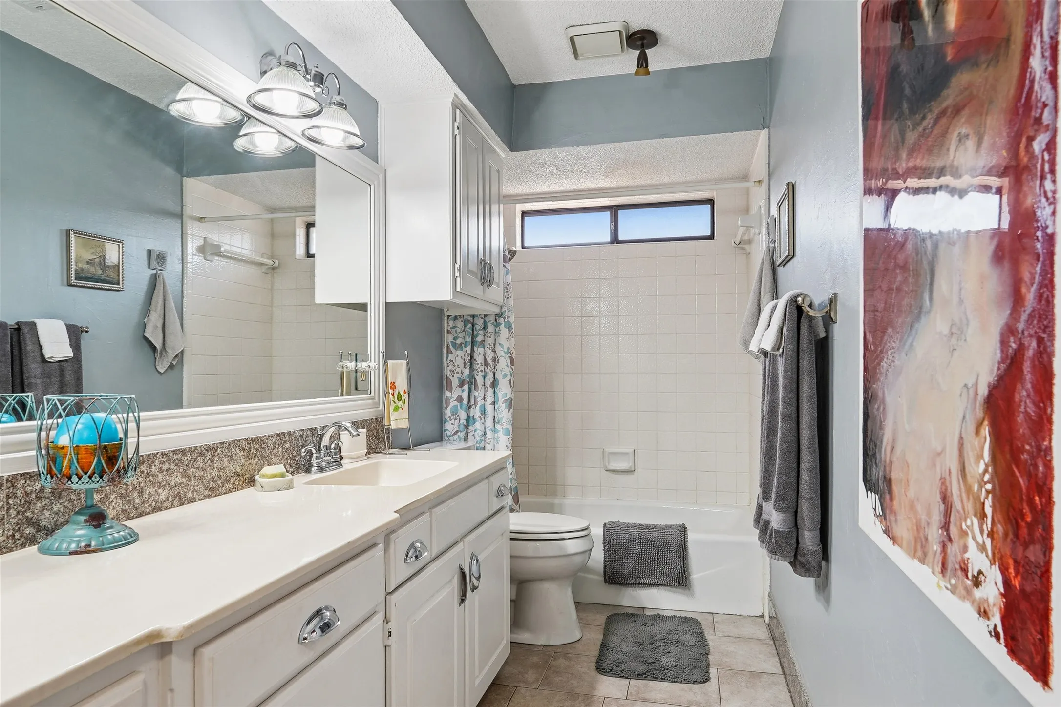 Extended vanity with integrated sink, white cabinetry, and polished chrome hardware