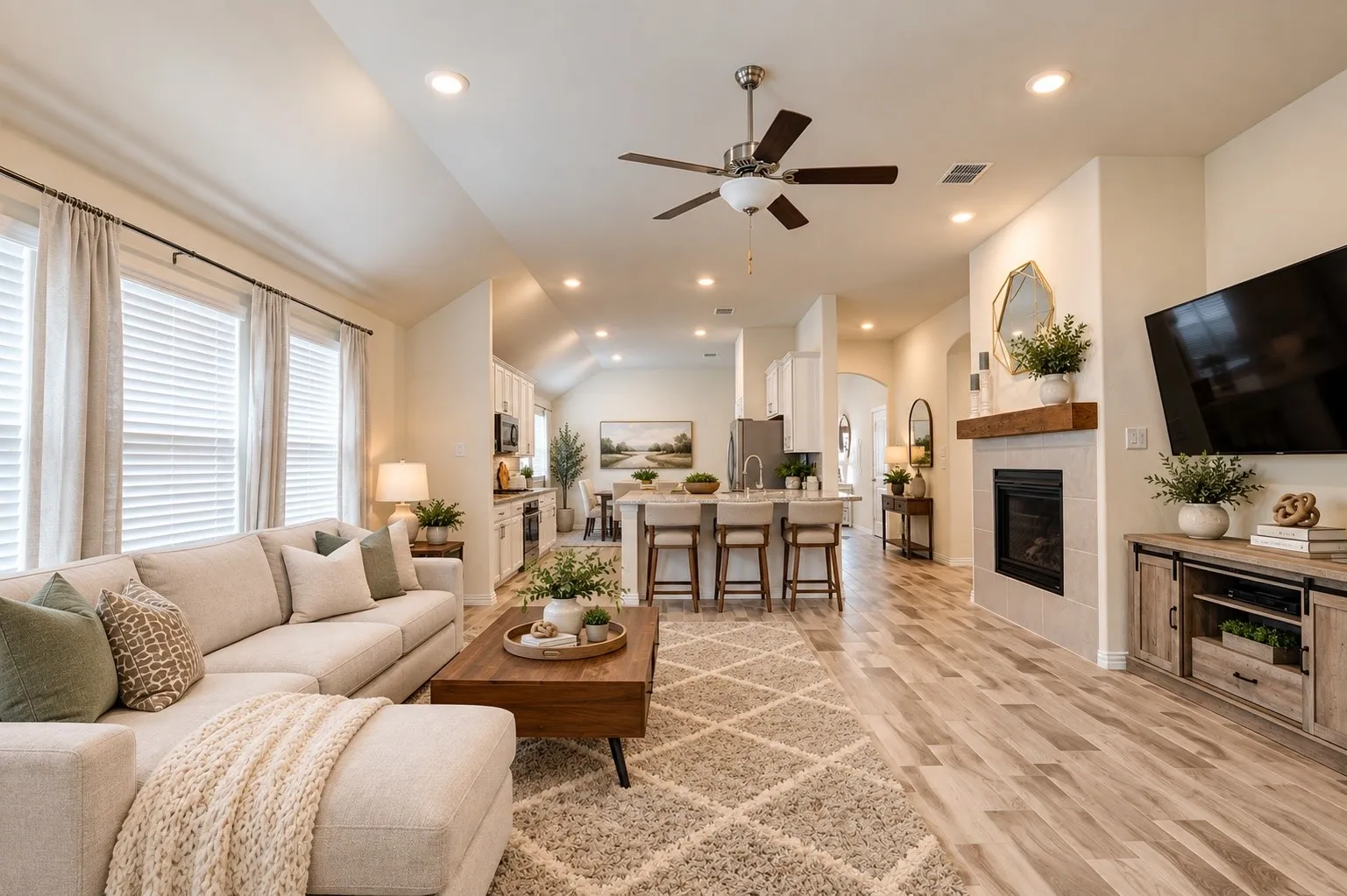 Spacious living area featuring wood-finish flooring, a tiled fireplace with a wood mantel, and recessed lighting