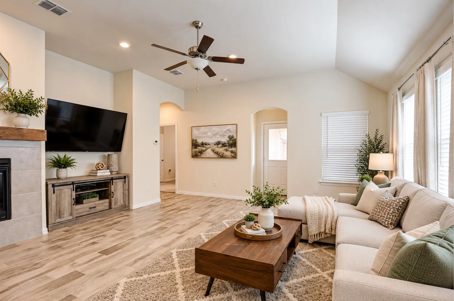 Living area featuring a vaulted ceiling, wood-finish flooring, and a fireplace with a wood mantel