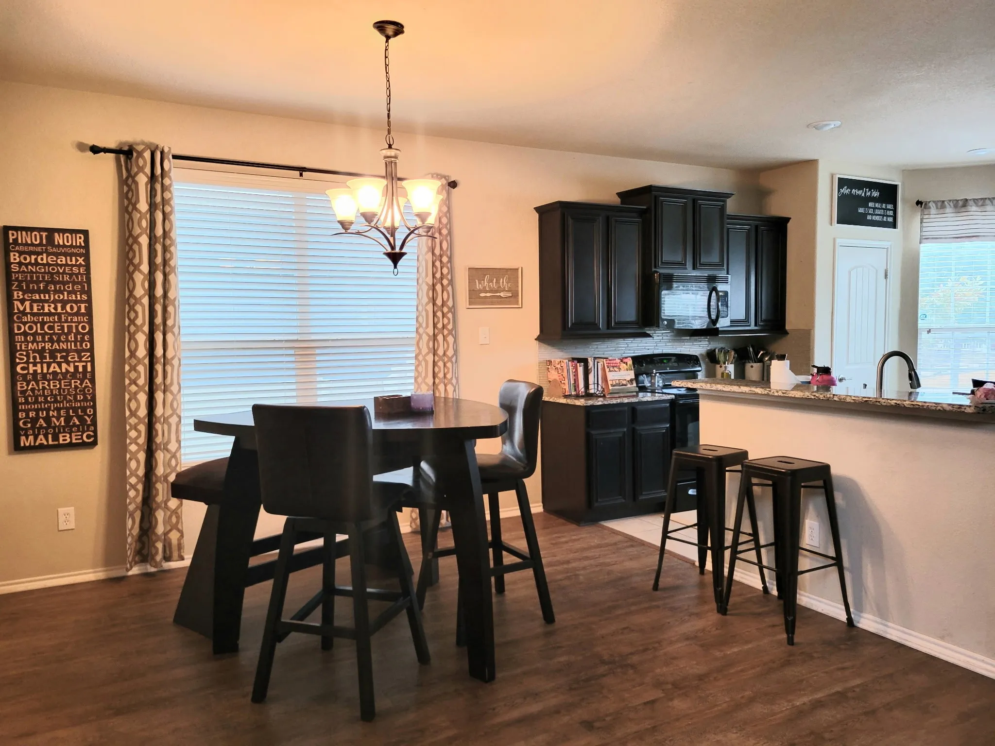 Wood-finish flooring throughout, dark cabinetry, and granite-style countertops