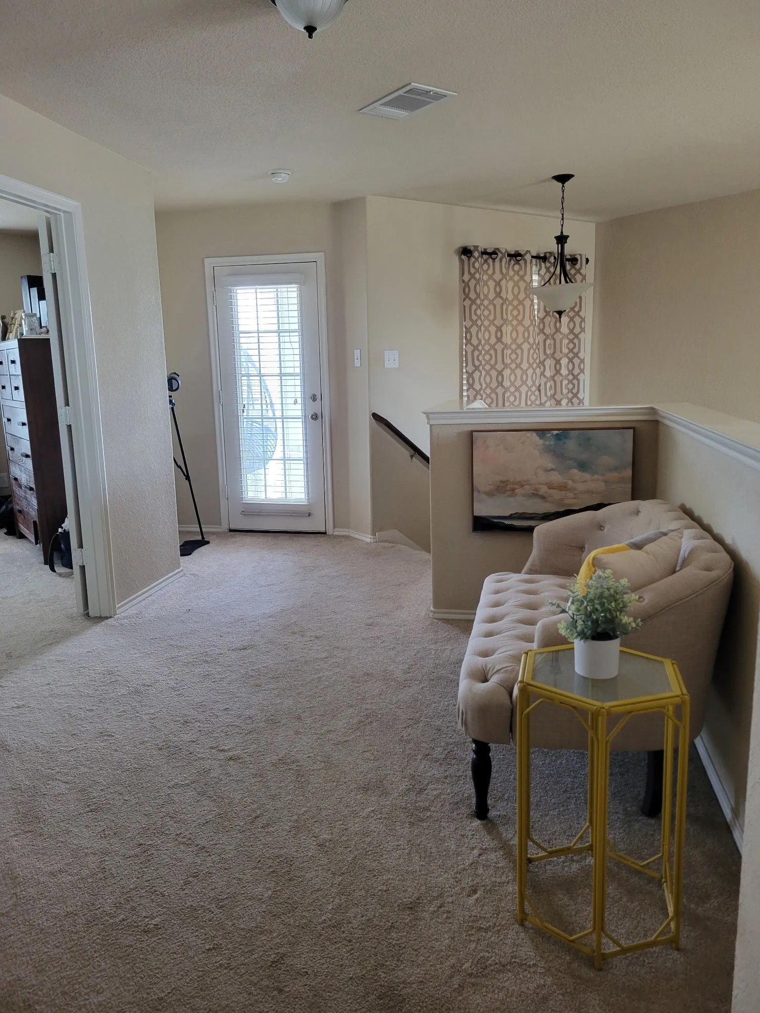 Plush carpeting throughout, white interior doors, and a decorative chandelier