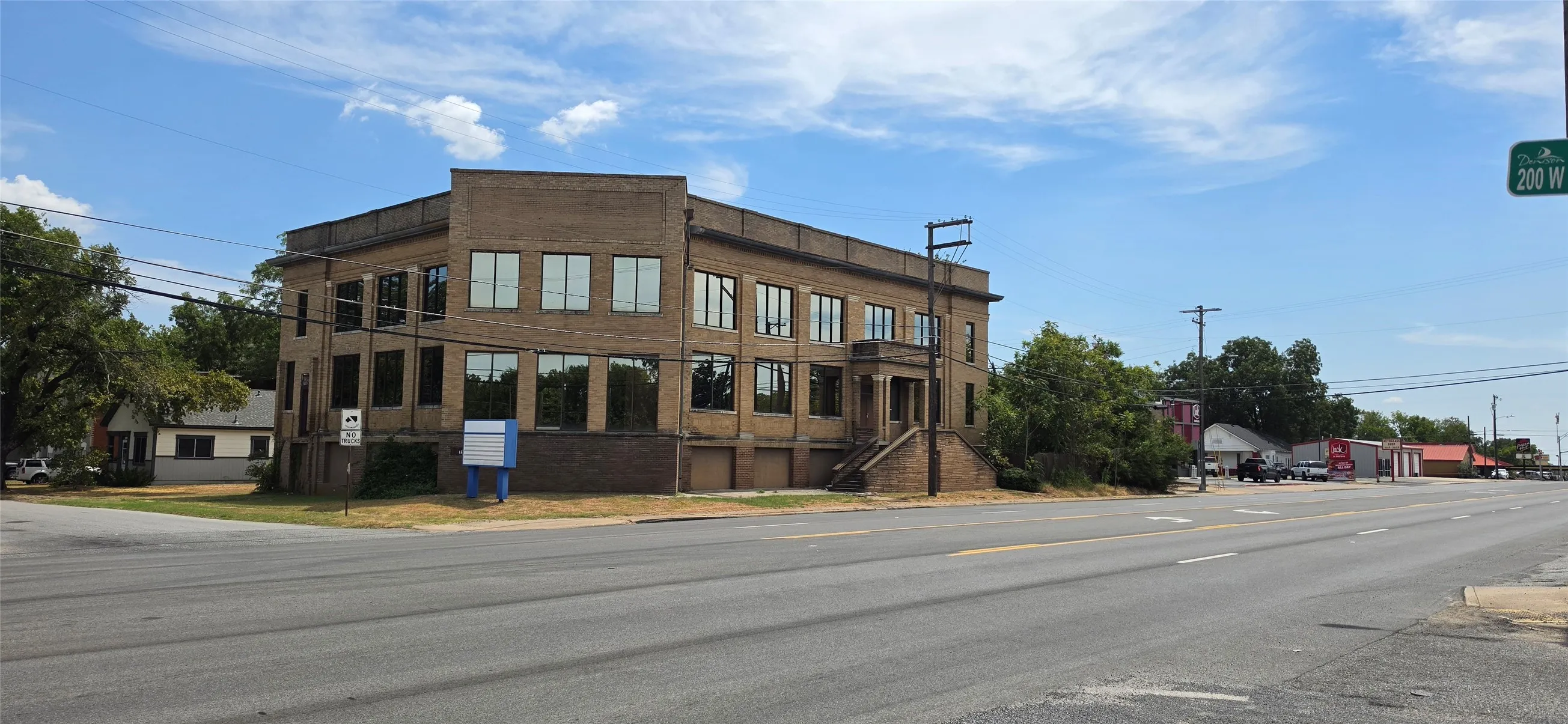 Brick facade building with multiple window openings and a prominent street corner location