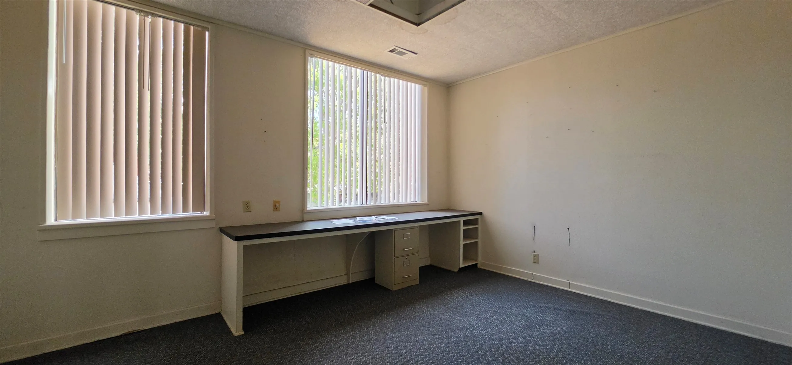 Built-in desk with a dark countertop and ample storage