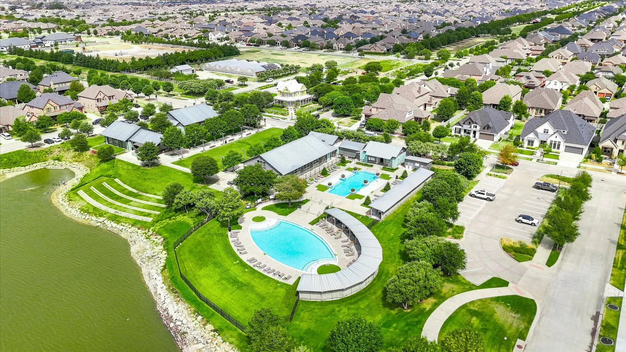 Expansive community featuring multiple residential properties, a large central swimming pool, a second swimming pool, and a recreational building