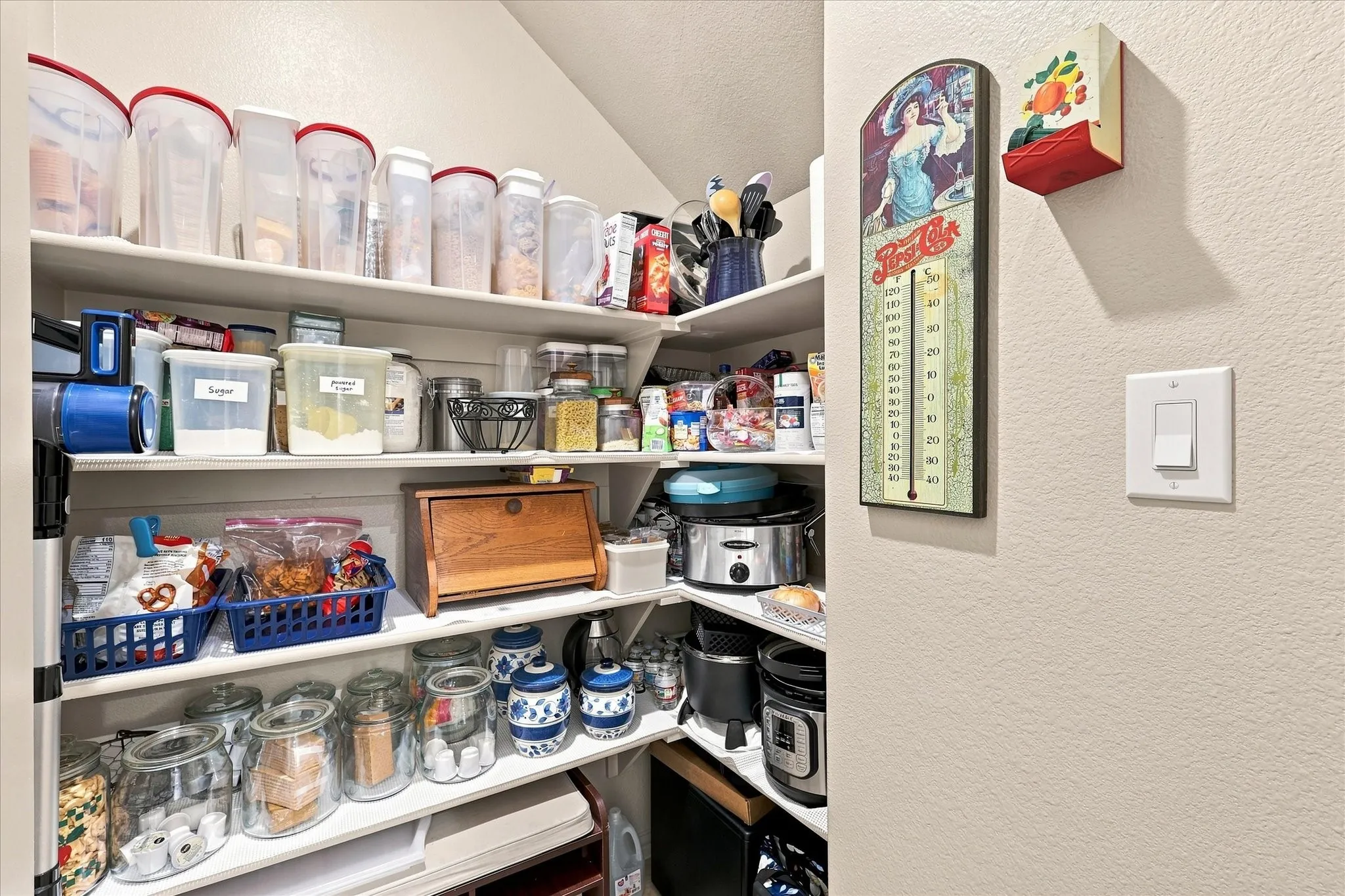 Large corner walk-in  pantry featuring multiple built-in shelves