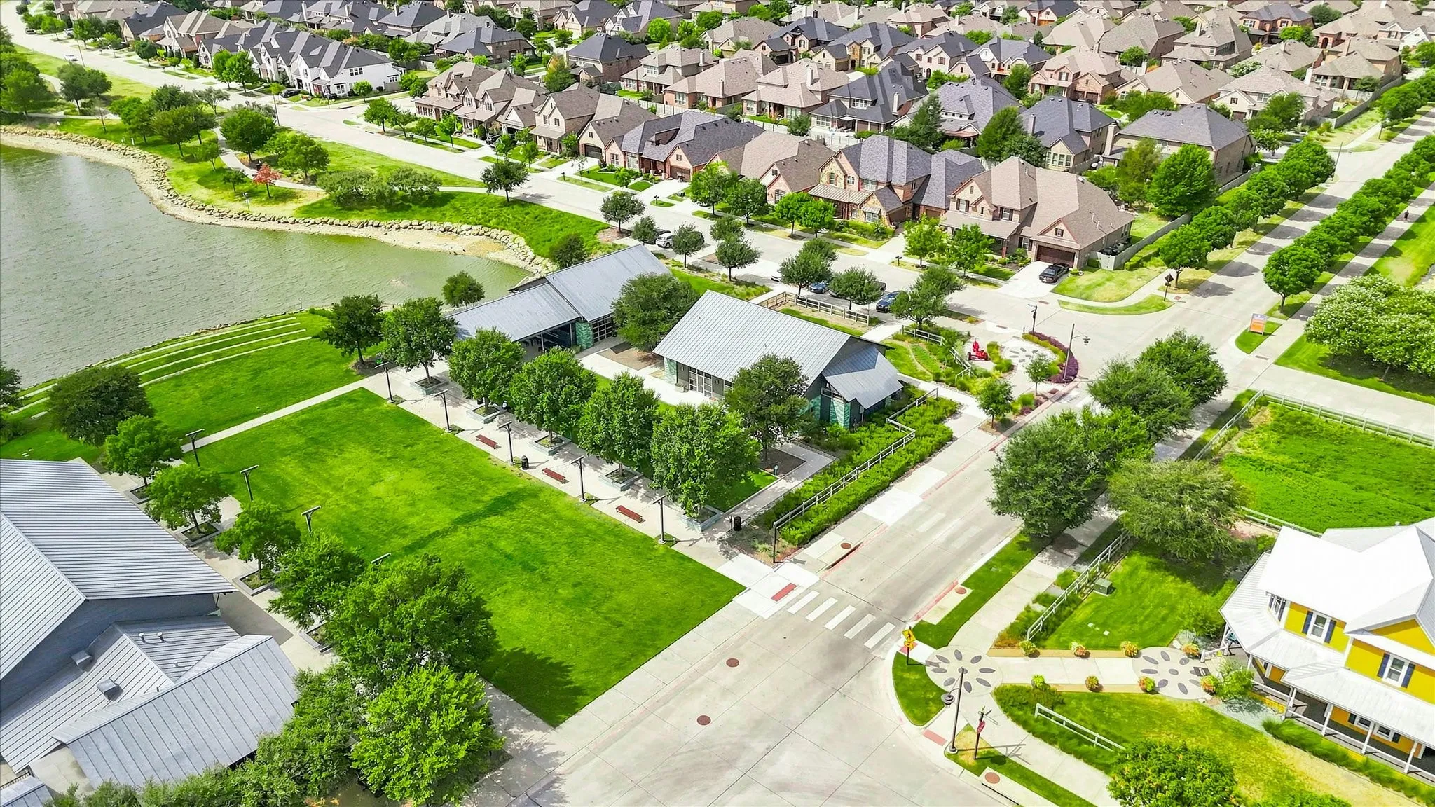 Community with extensive green spaces, a prominent body of water, and structured​​‌​​​​‌​​‌‌​‌‌​​​‌‌​‌​‌​‌​​​‌​​ streetscapes