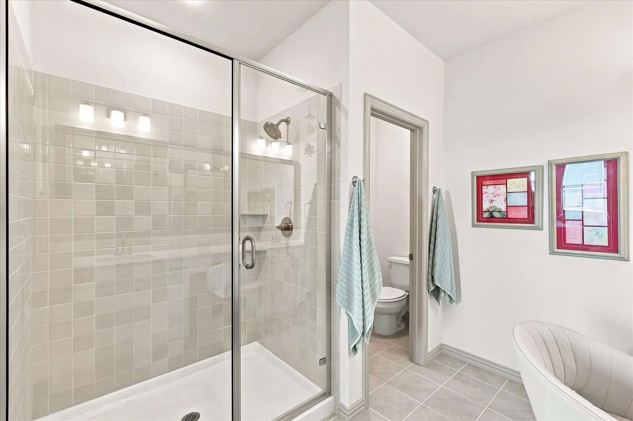 Oversized subway tile surround shower with water closet for privacy.