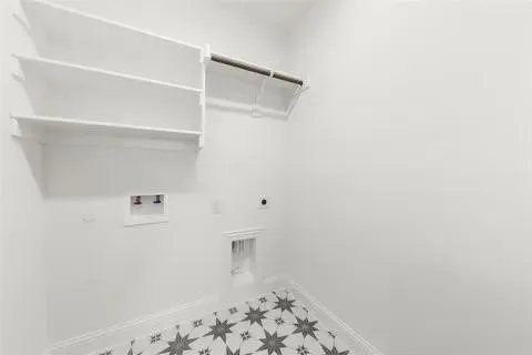 Built-in shelving, hanging rod, patterned floor tile, and white wall finishes