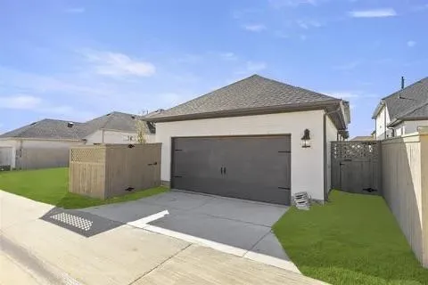 Attached garage with a dark gray door, white exterior siding, and a gabled roof