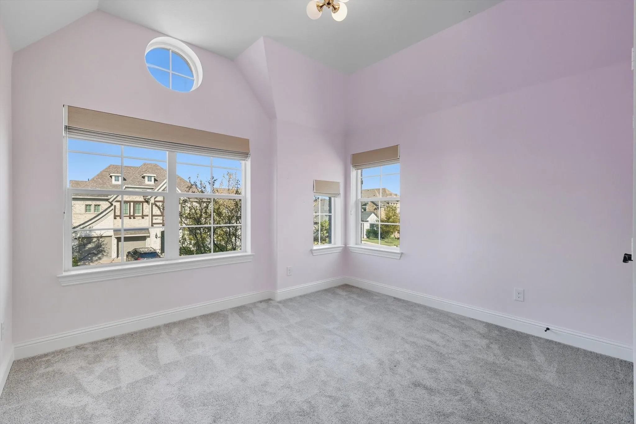 Unfurnished room with light carpet and lofted ceiling
