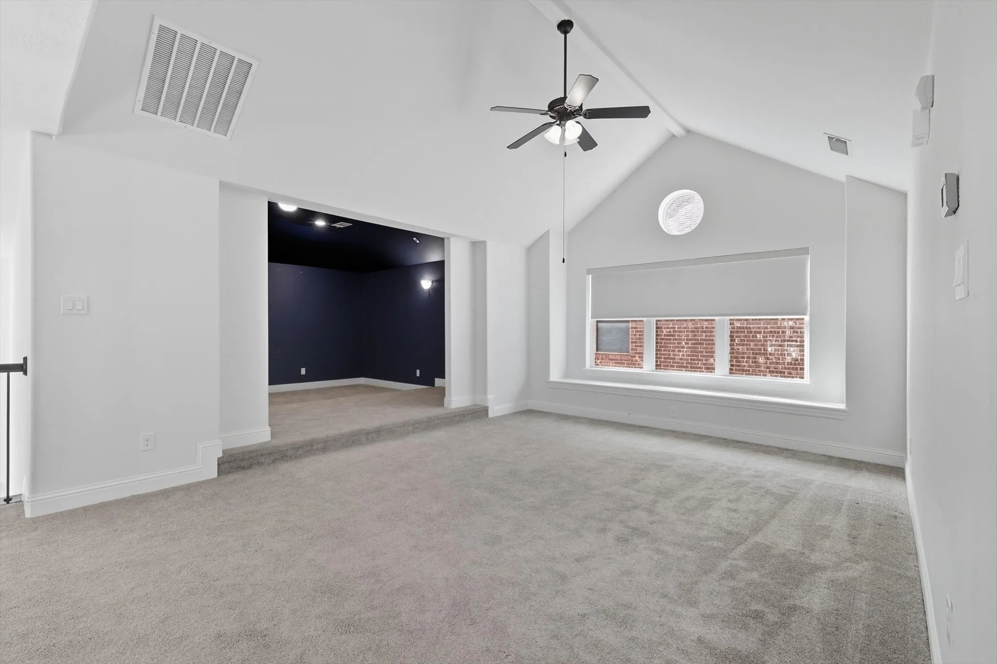 Empty room with light carpet and a ceiling fan