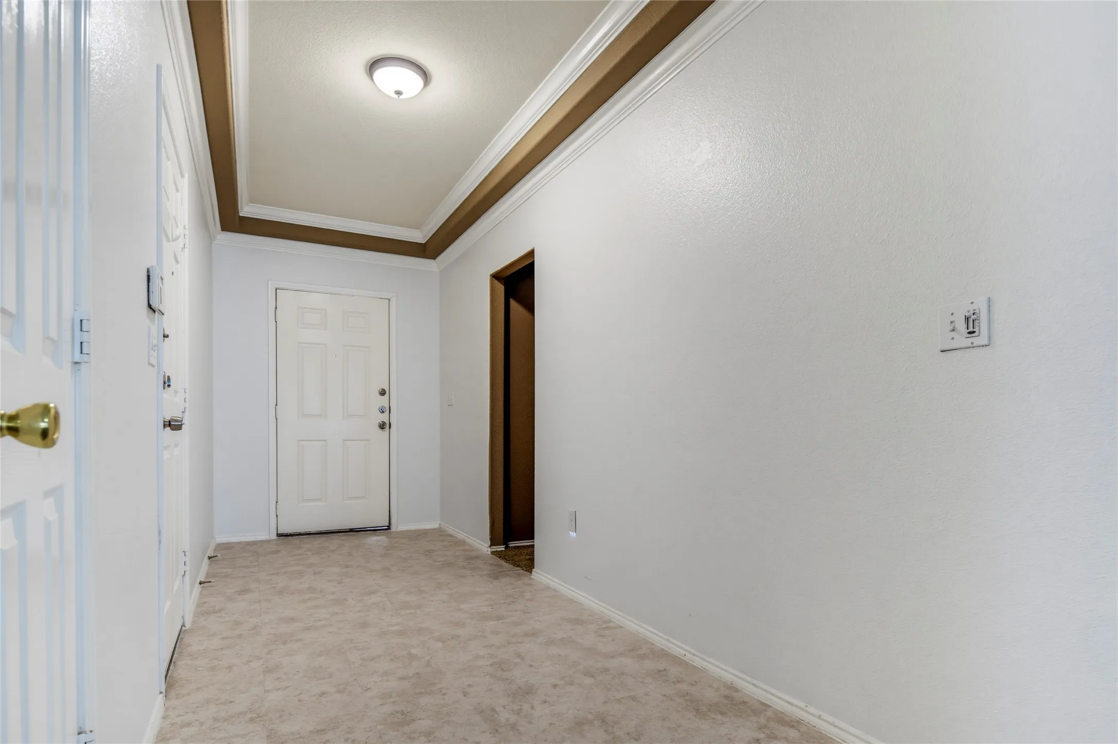 Entryway featuring a white paneled door, flush-mount ceiling light, and crown molding
