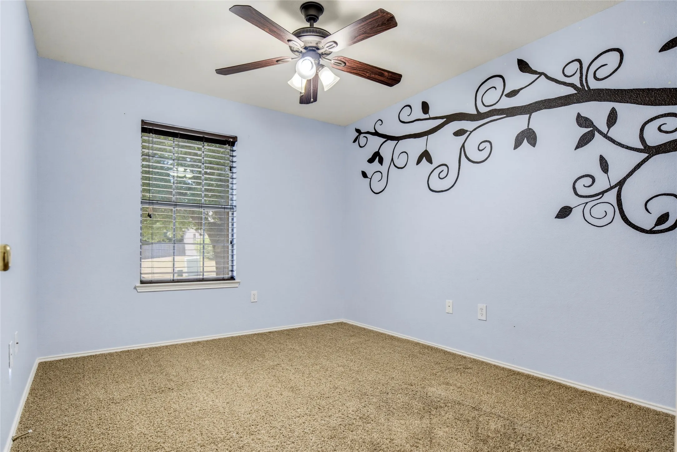 Carpeted room featuring a ceiling fan with integrated lighting, a window with blinds, and wall decor