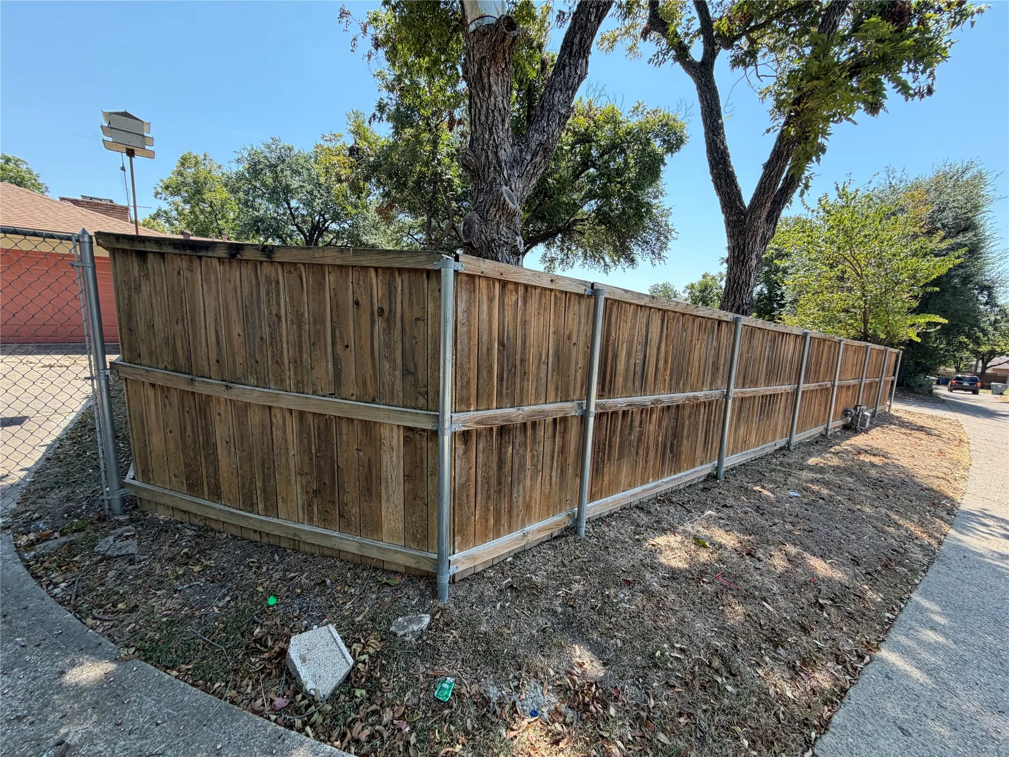 Wood privacy fence with metal posts and a chain-link gate