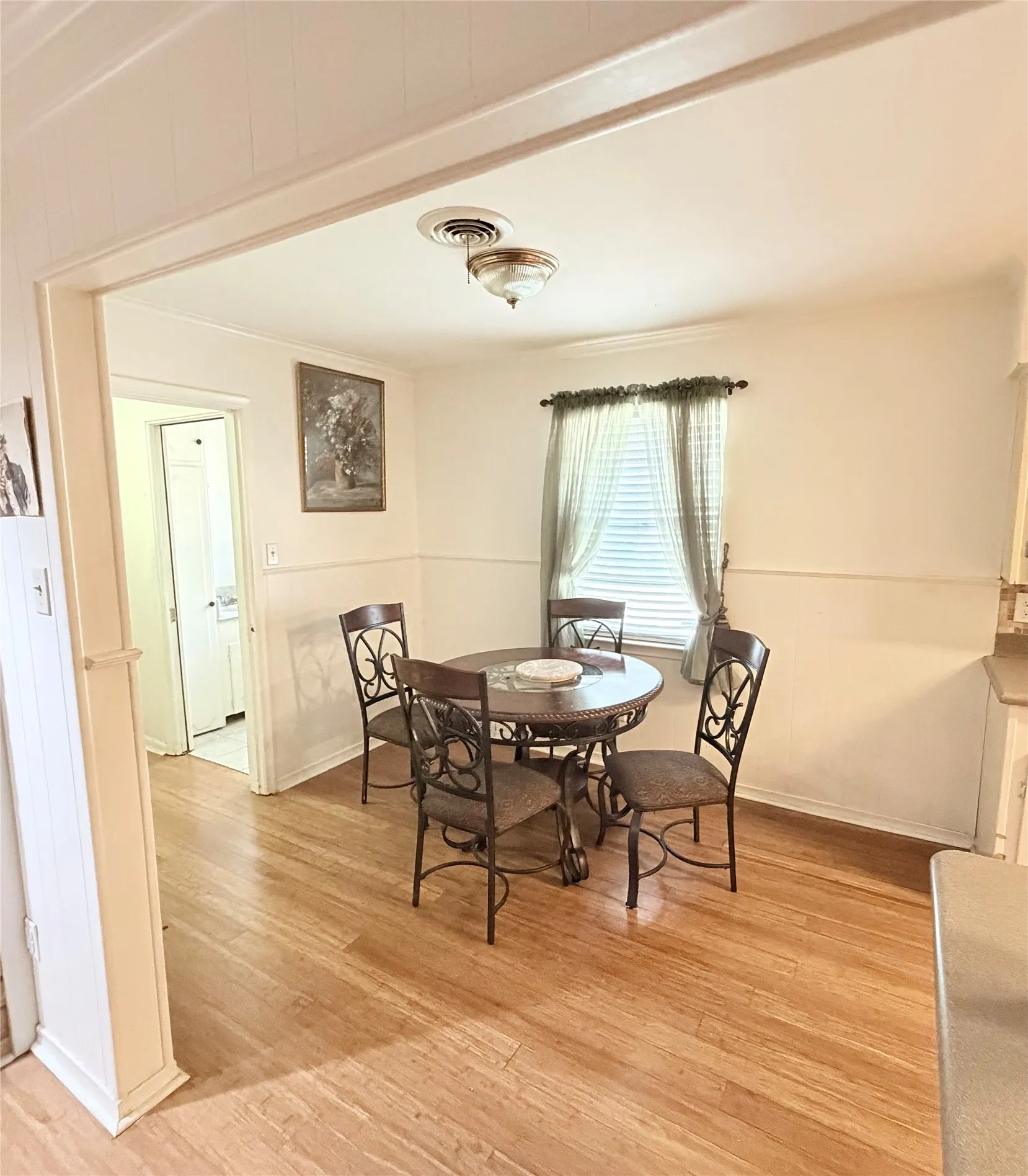 Wood-finish flooring, recessed lighting, and a single window with blinds