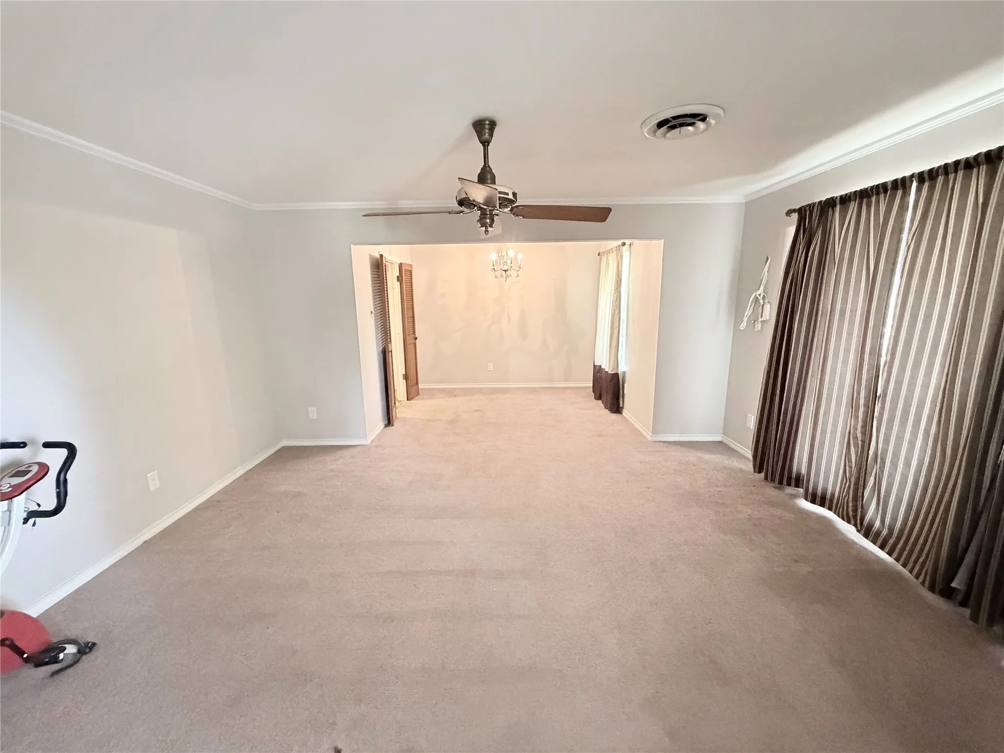 Carpeted flooring throughout, crown molding, and a ceiling fan with integrated lighting