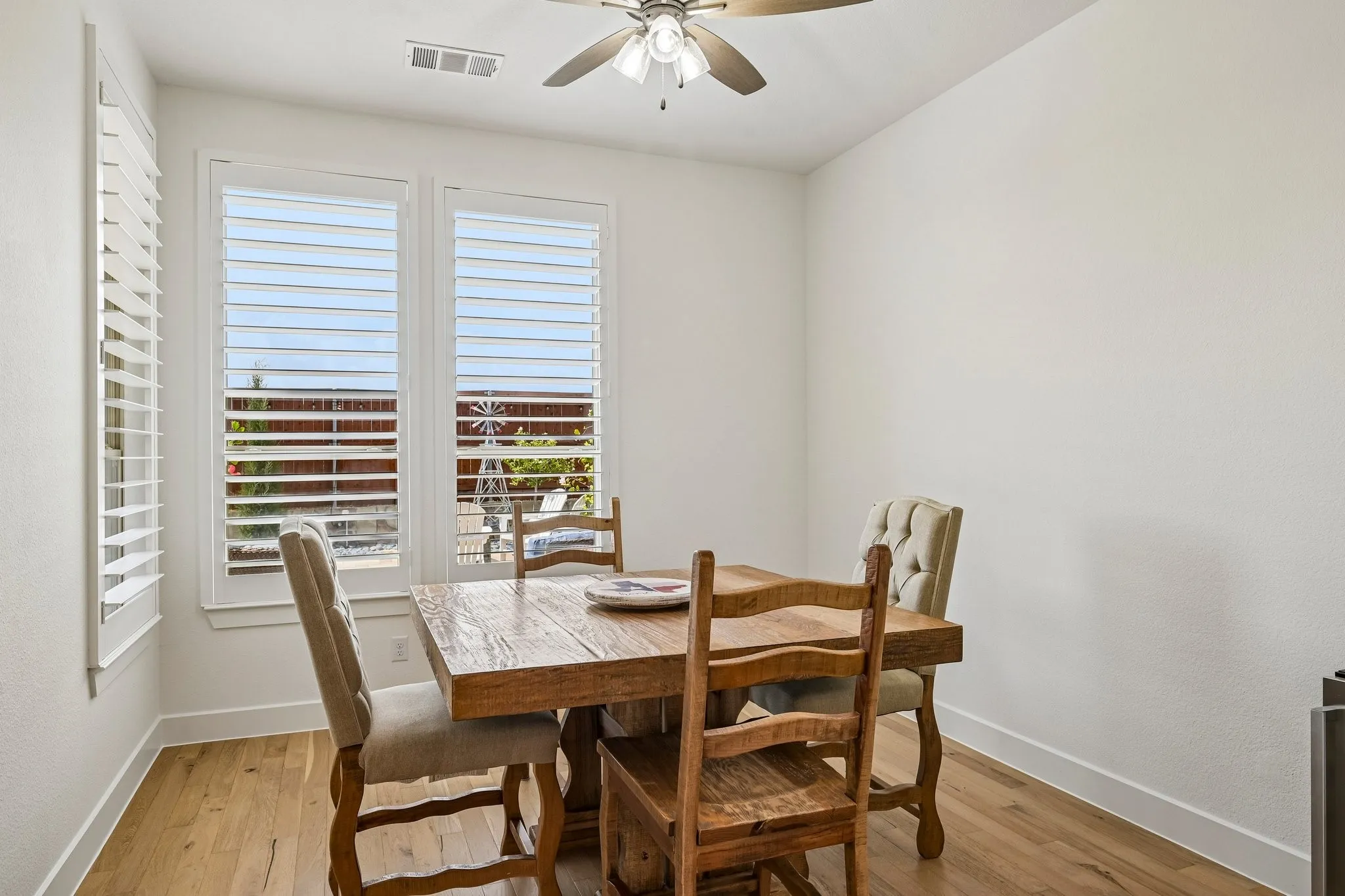 Wood flooring, white walls, and a ceiling fan