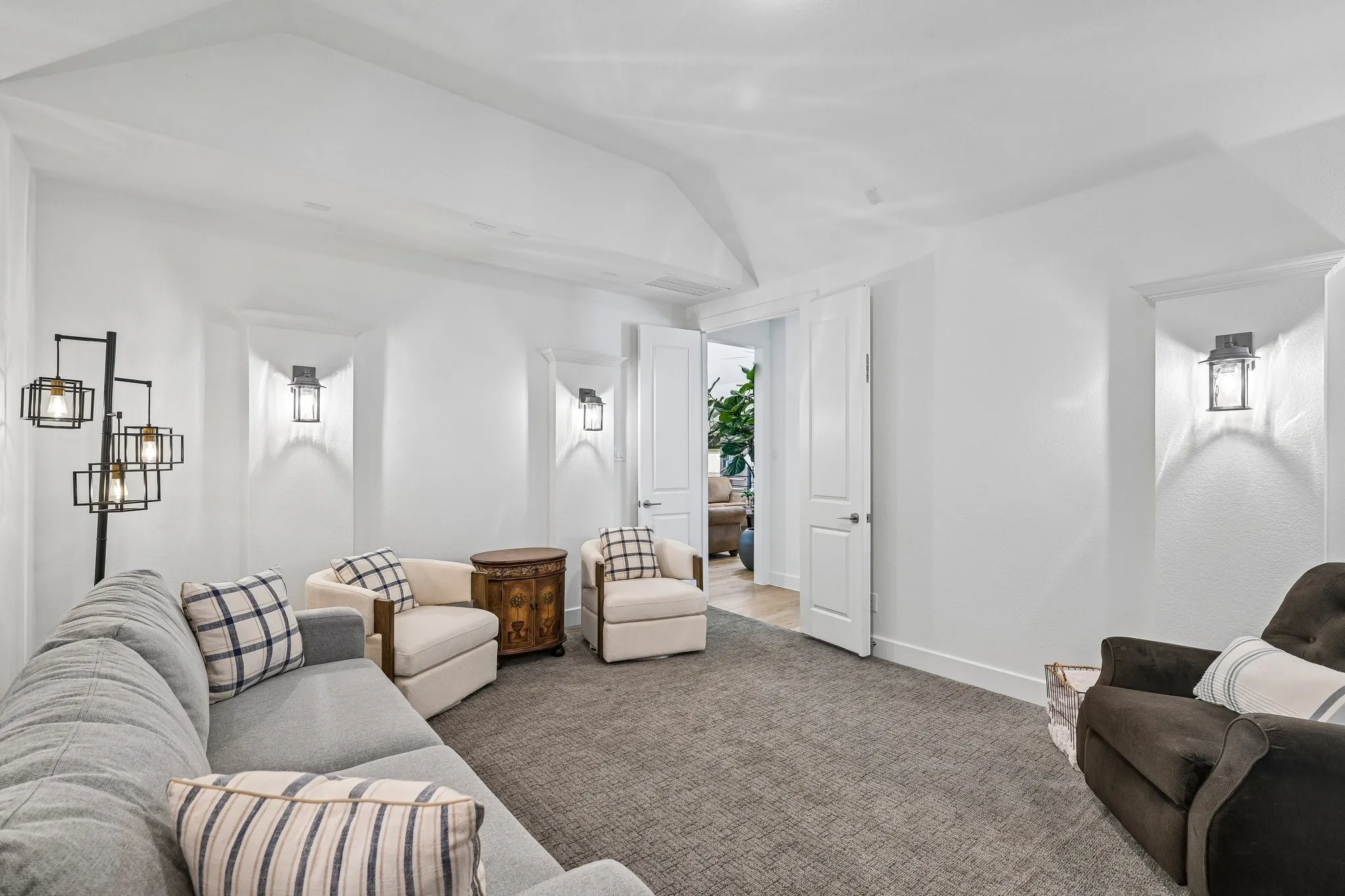Recessed wall sconces, white painted walls, and textured carpeting
