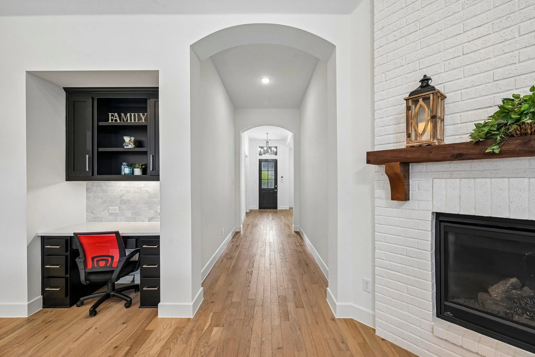 Built-in desk with dark cabinetry and light-toned backsplash