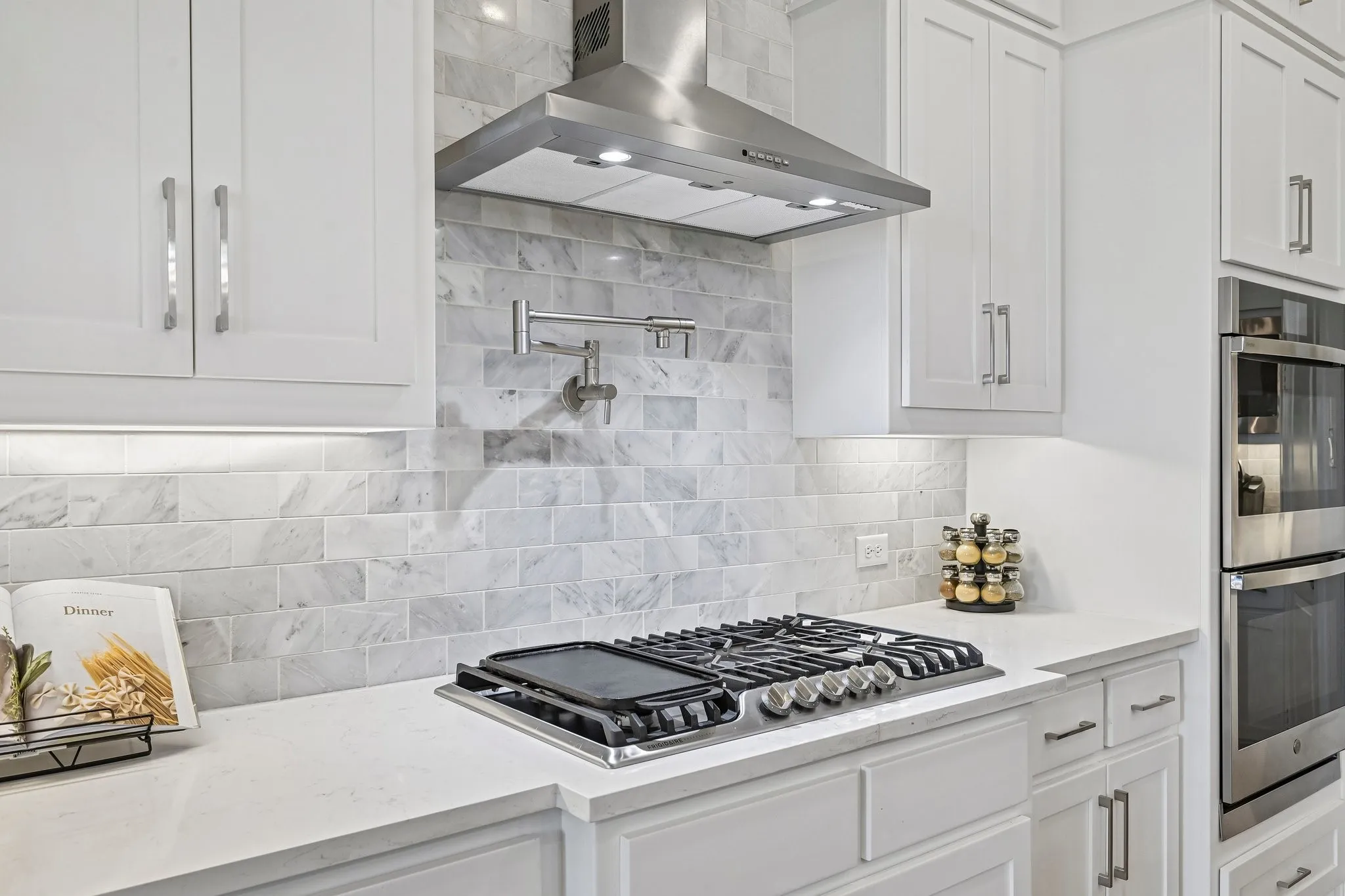 Stainless steel gas range, coordinating range hood, and double wall ovens