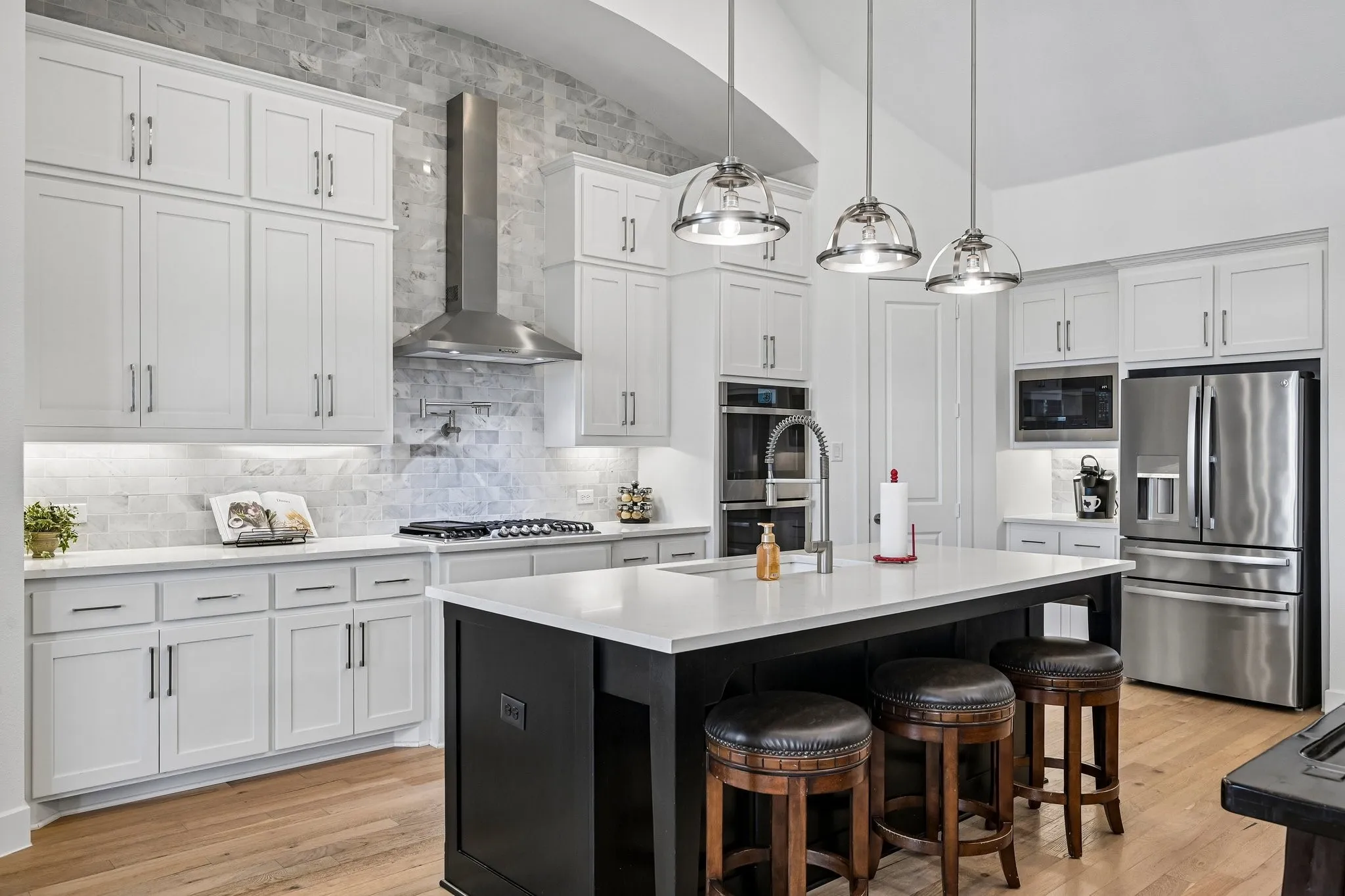 Chef's kitchen featuring a stainless steel gas range, built-in double oven, and stainless steel refrigerator